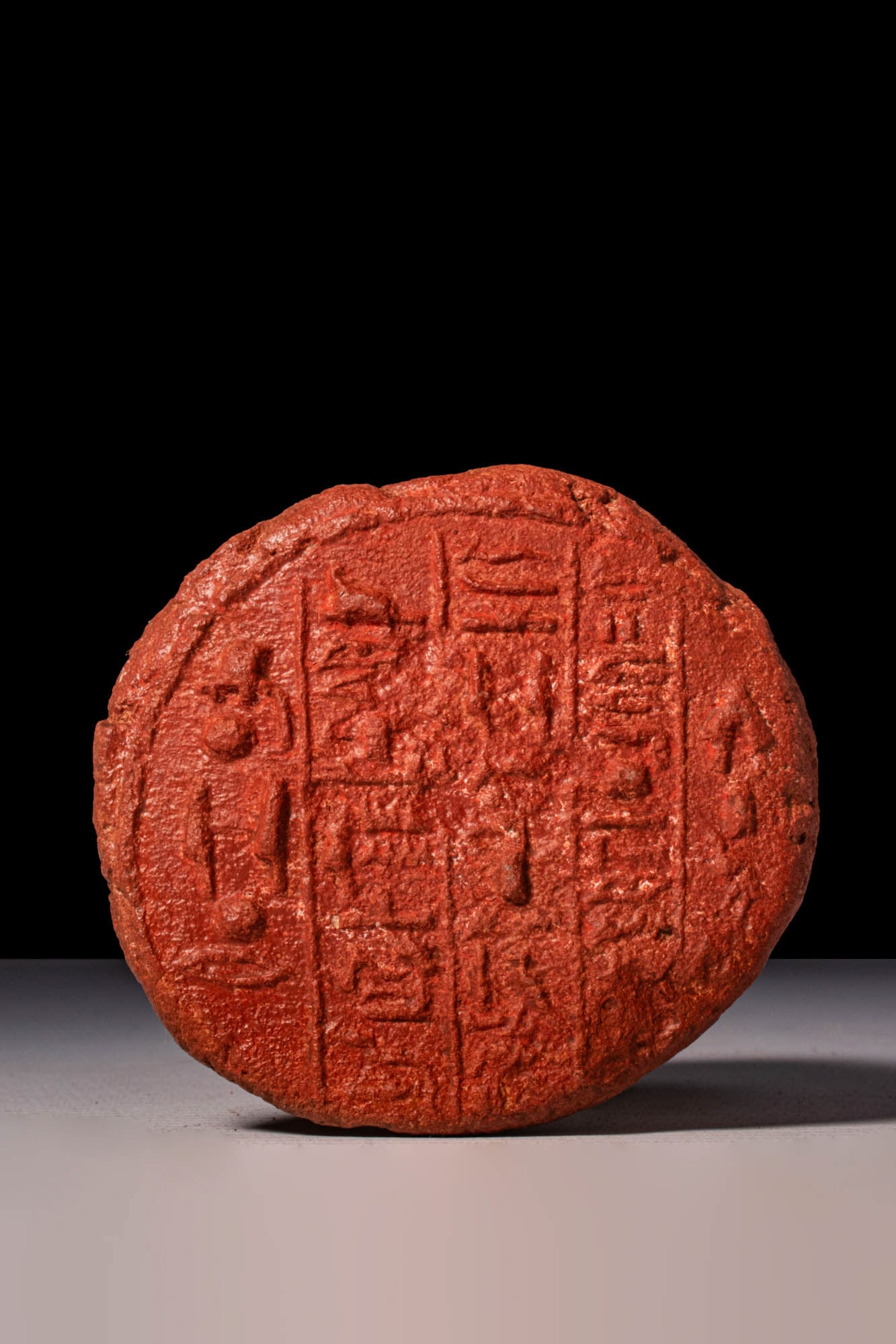 EGYPTIAN TERRACOTTA FUNERARY CONE WITH HIEROGLYPHIC INSCRIPTION - TRANSLATED: New Kingdom, Ca. 1550 - 1069 BC. A terracotta funerary cone with a wide circular face bearing vertical columns of hieroglyphic text within a raised border.?Partial translation of the hieroglyphic