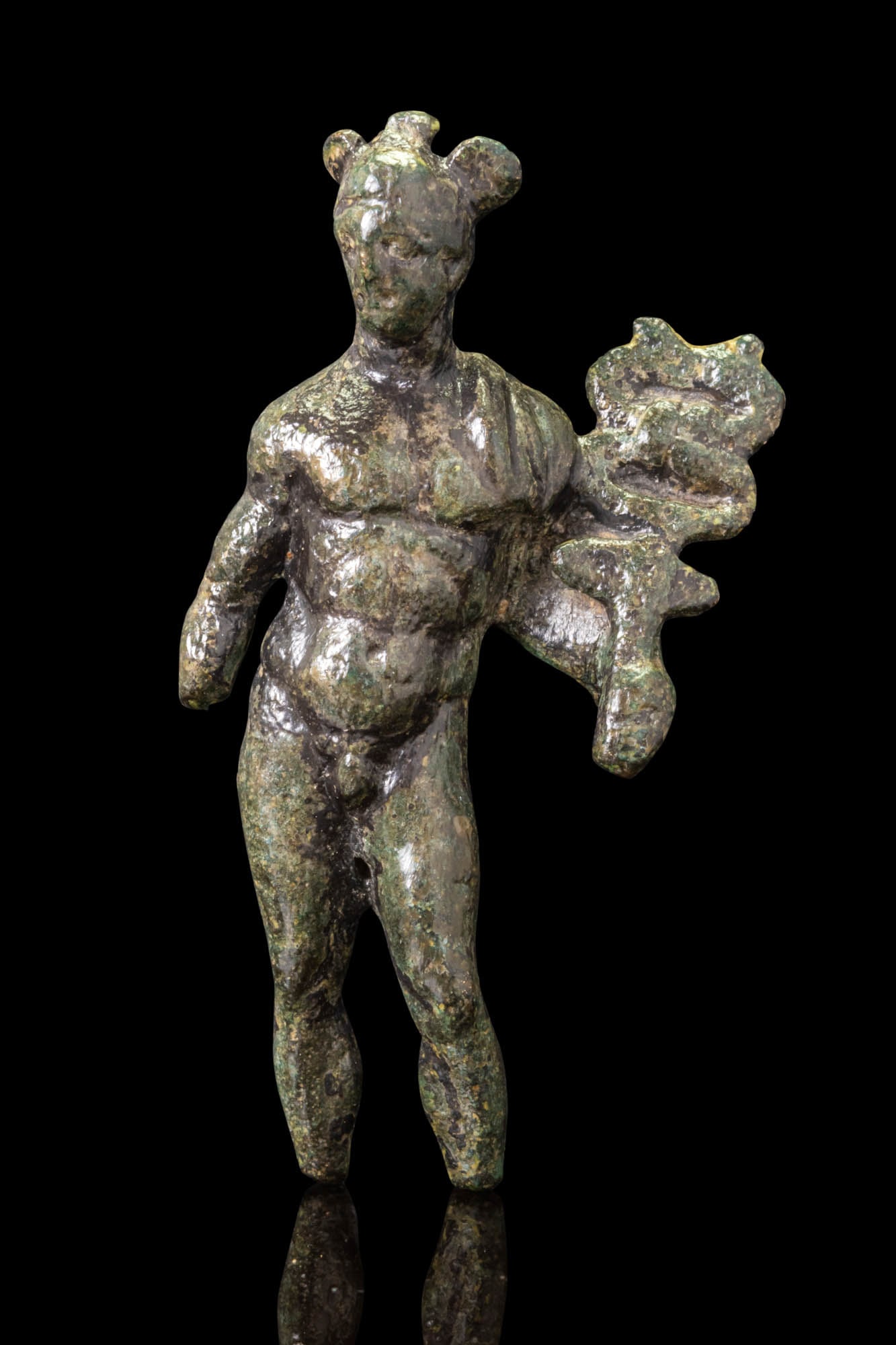 ROMAN BRONZE FIGURINE OF MERCURY: Ca. AD 200 - 300. A bronze figurine of Mercury shown nude, standing with weight on the right leg. His head is topped with a winged petasos. The left hand is lowered and supports a caduceus with coiled