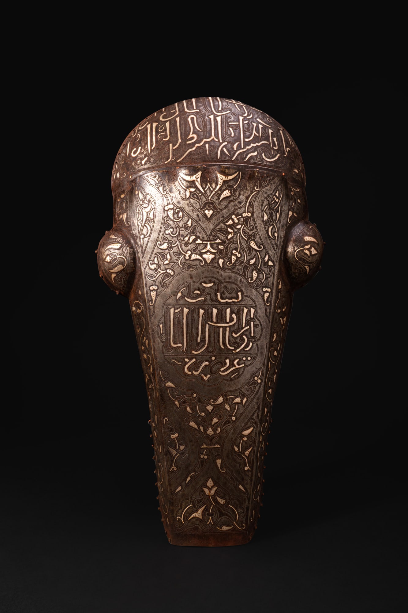 SAFAVID OR OTTOMAN BRONZE INLAID CHAMFRON: Ca. AD 1600 - 1800A horse chamfron formed as a single plate with a rounded crown, a long tapering face, and prominent circular bosses projecting at the sides to protect the eyes. The edges are pierced