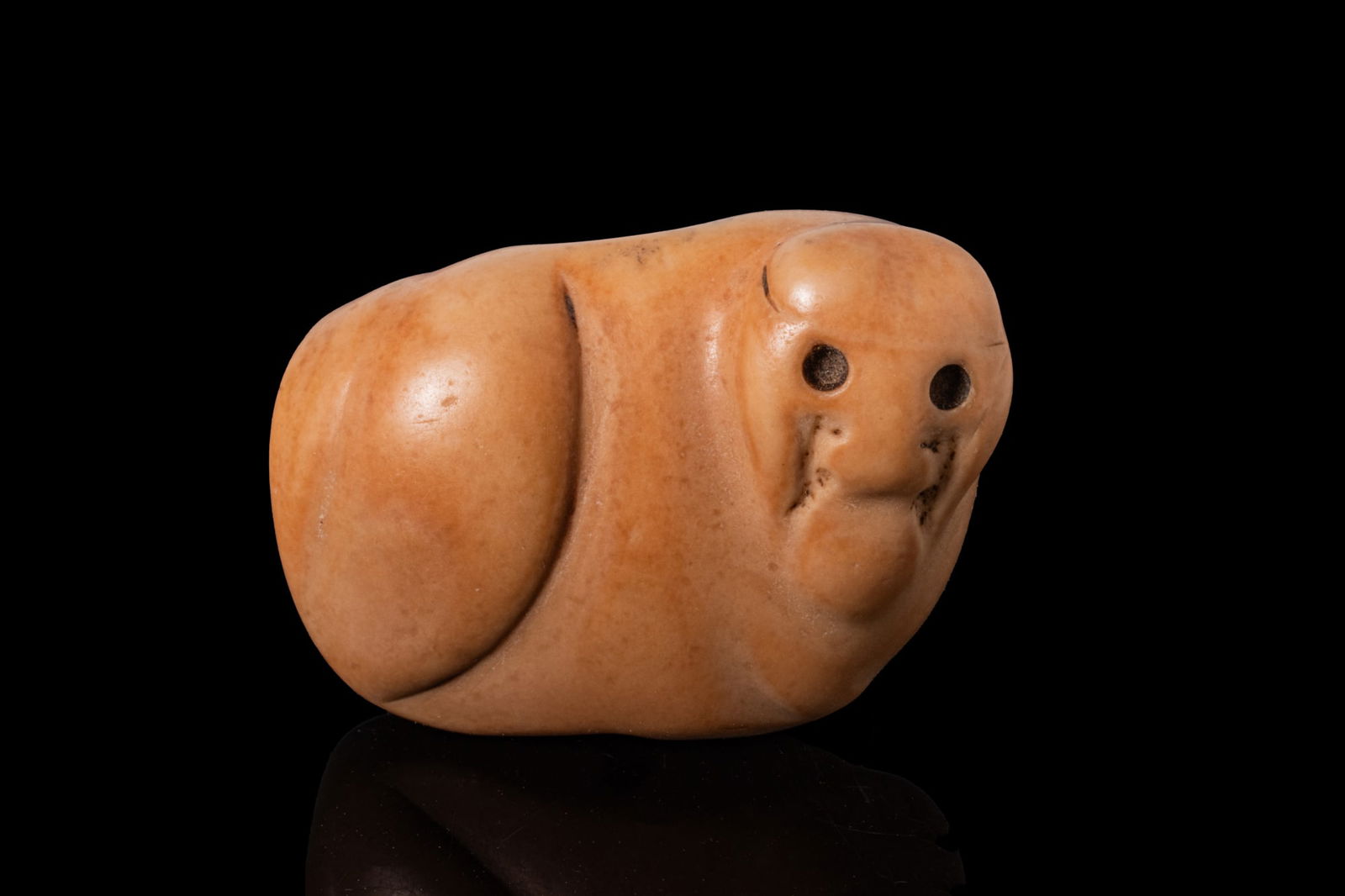 MESOPOTAMIAN STONE QUADRUPED AMULET SEAL: Ca. 3000 BCA stone amulet seal in the form of a stylised recumbent quadruped with a rounded body and a deep vertical groove along the back. The compact head with a blunt snout has recessed circular ey