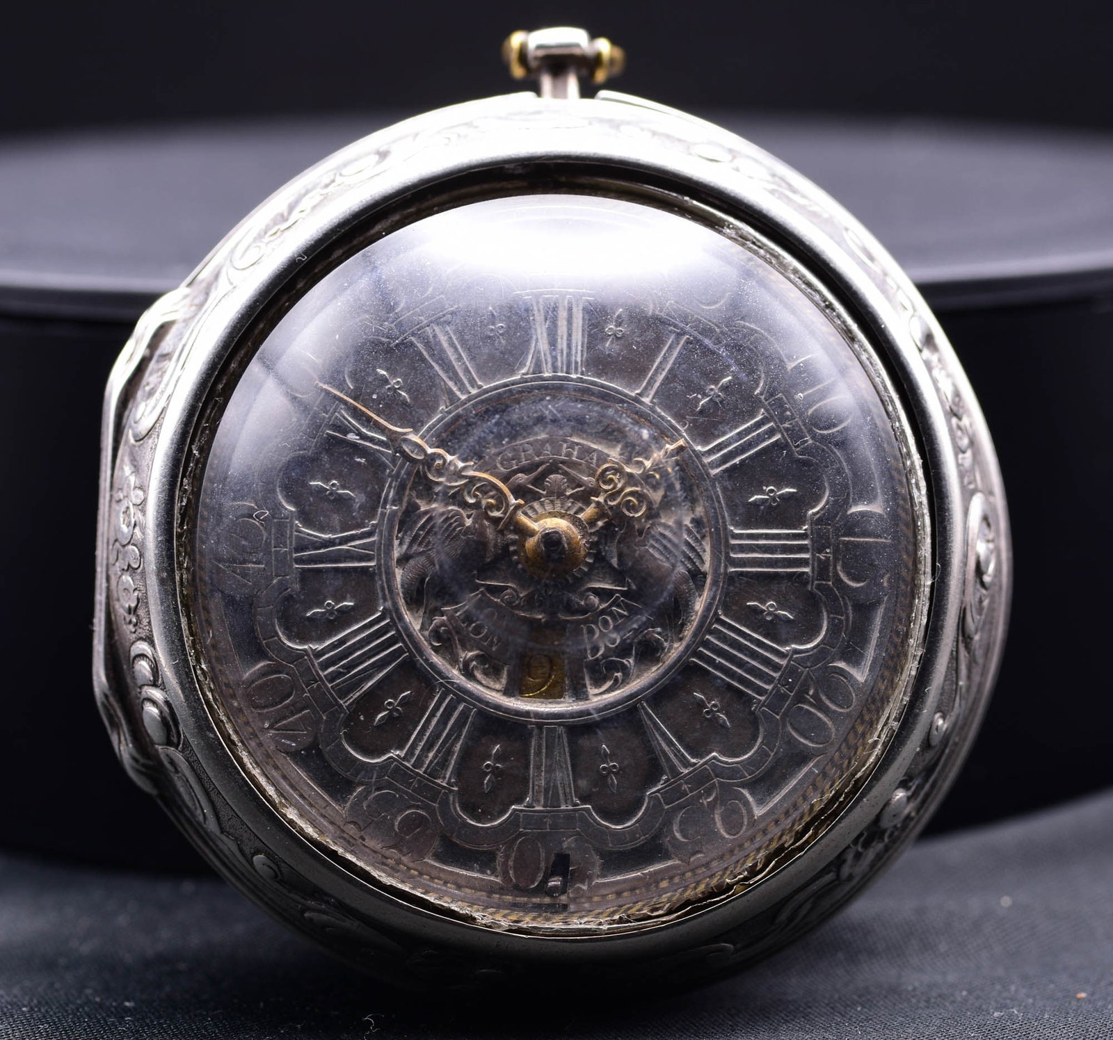 A Rare Large Silver Repouss? Pair Cased Verge Calendar Pocket Watch With Enamel Depiction On Outer C: C. 1750BA very fine and large Georgian silver pair-cased verge pocket watch, signed 'Graham London', circa mid-18th century. The robust gilt fusee movement with verge escapement is protected within an