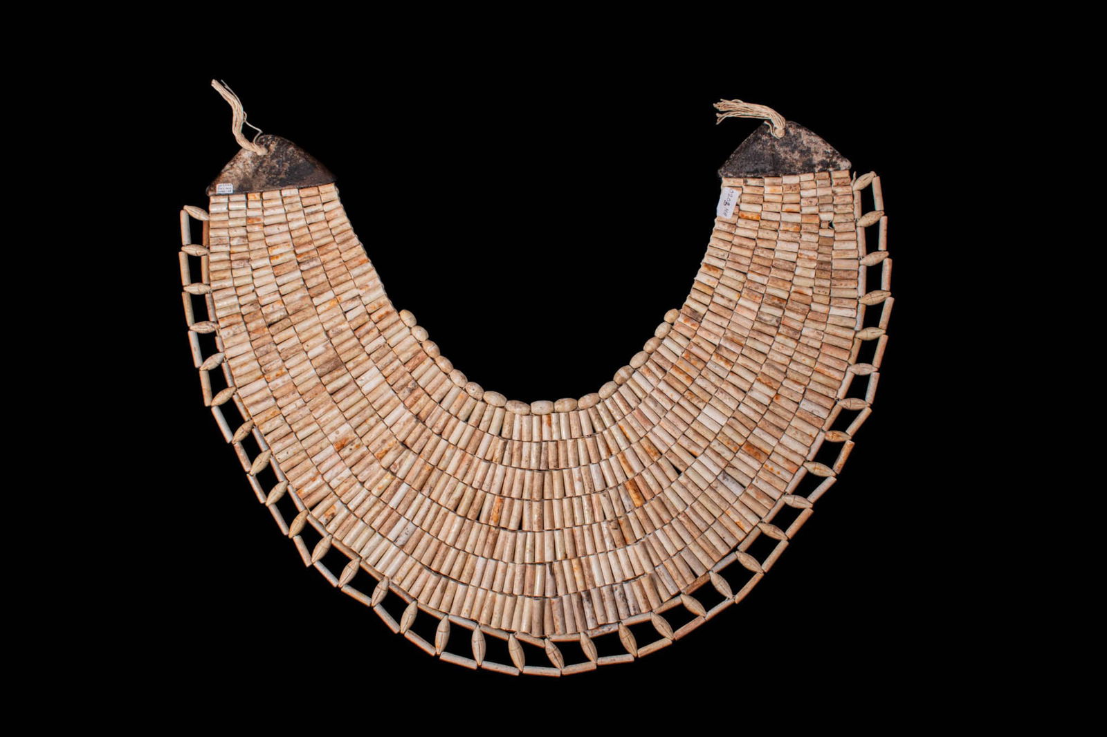 STUNNING EGYPTIAN FAIENCE PECTORAL COLLAR: Middle Kingdom, Ca. 2055 - 1790 BC. A broad faience wesekh collar, formed as a semi-circular pectoral with multiple rows of tubular and biconical beads threaded in close horizontal registers, widening