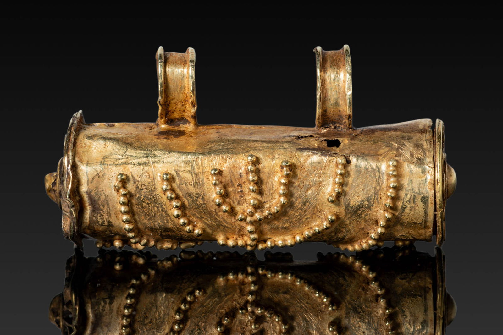LATE ROMAN / EARLY BYZANTINE ELECTRUM SCROLL / AMULET CASE WITH MENORAH: Ca. AD 400 - 500. A cylindrical electrum scroll/amulet case decorated in granulation with a central menorah flanked by a palm frond and a shofar (ram's horn). Each end is closed by a circular terminal