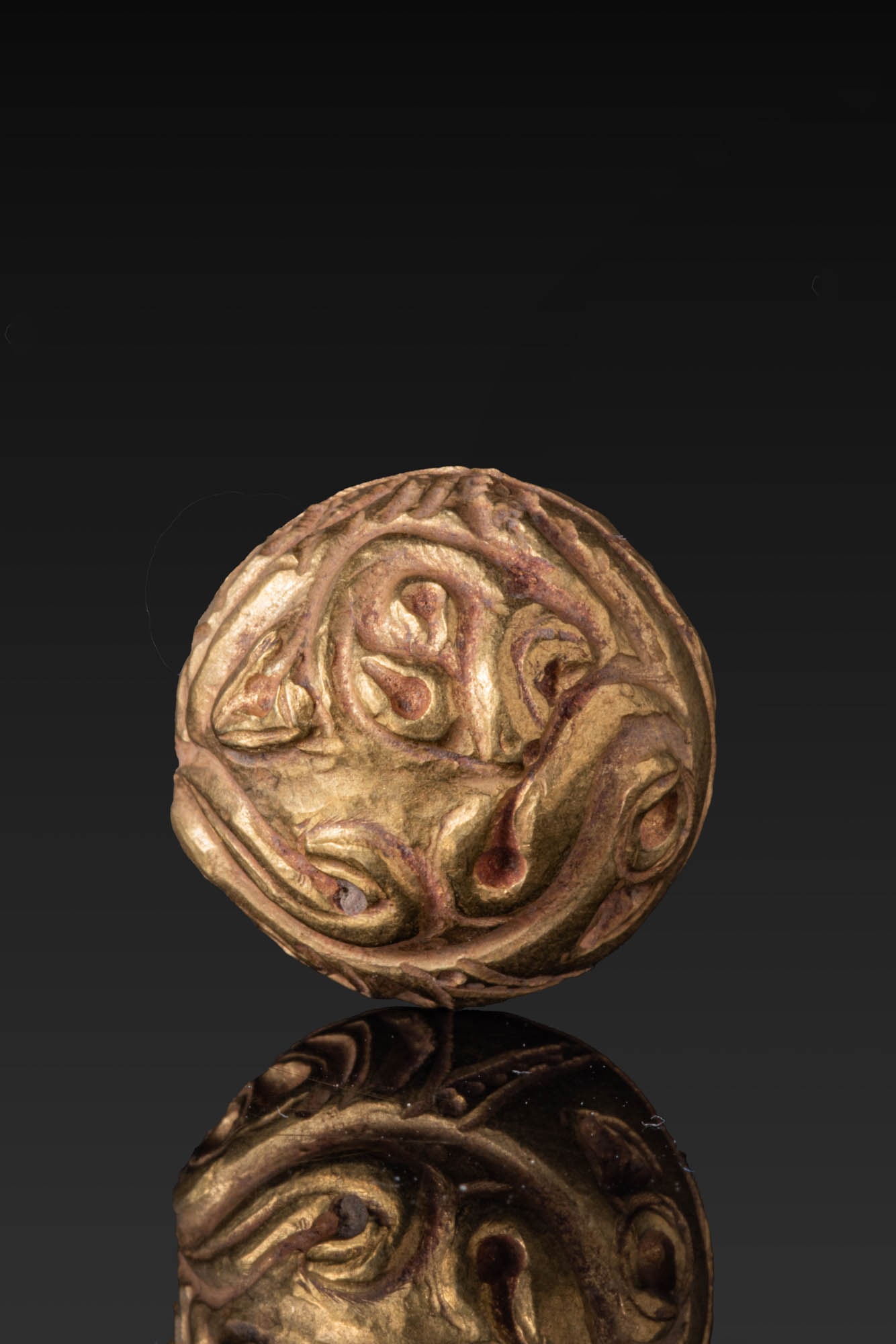 STUNNING VIKING HIGH KARAT GOLD APPLIQUE WITH GRIPPING ANIMALS: Ca. AD 900 - 1100. A domed gold appliqu? with interlaced gripping animals in relief, framed by a narrow border. The reverse is hollow, with a single loop for attachment. Size: 15mm x 15mm; Weight: 2.8