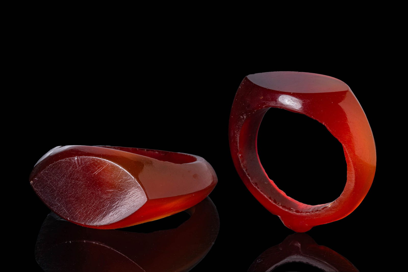 EGYPTIAN CARNELIAN RING: New Kingdom, Ca. 1550 - 1069 BC. A carnelian ring with an elliptical bezel and a carinated hoop expanding at the shoulders, with a raised knob at the back. Size: D:18.75mm / US: 8 3/4 / UK: R; Weight: