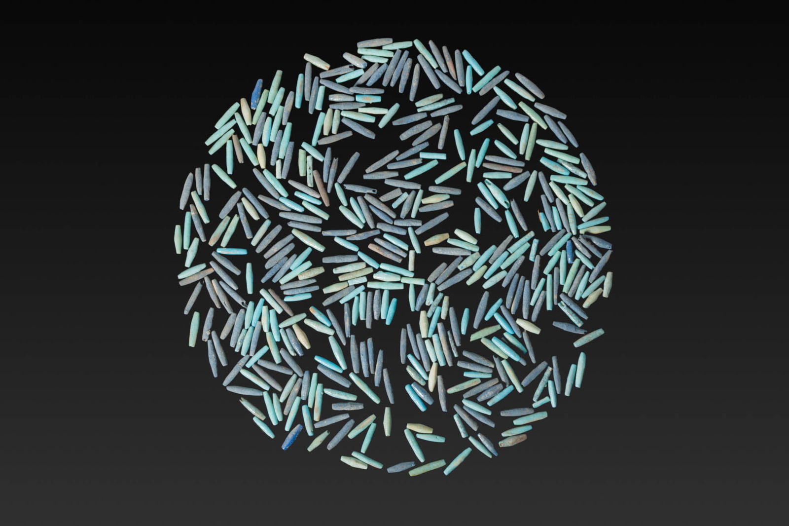 LARGE COLLECTION OF EGYPTIAN FAIENCE TUBULAR BEADS: New Kingdom to Late Period, Ca. 1550 - 664 BC. A large collection of faience tubular and biconical beads in mixed blue-turquoise hues, each drilled longitudinally. Size: 13-16mm x 2-3mm; Weight: 59g P