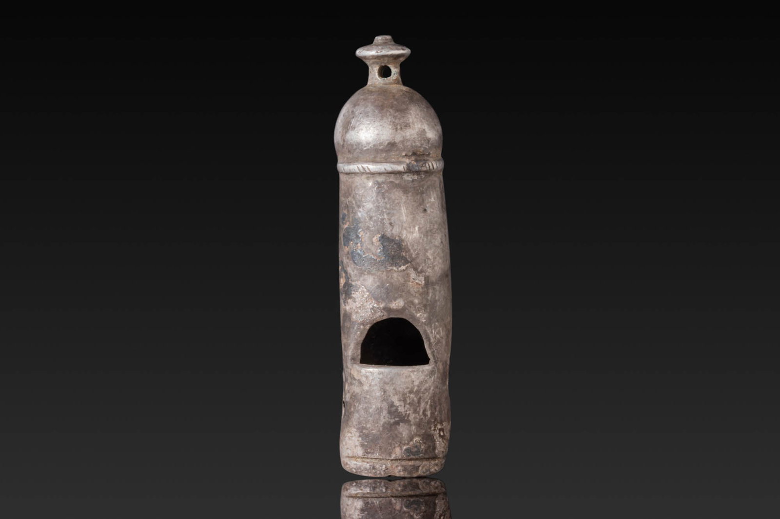 ROMAN LEGIONARY SILVER WHISTLE: Ca. AD 1 - 300. A silver whistle formed as a tapering tube with a domed cap, surmounted by a short knop. The tube is cut with an arched sound window to the front and a lateral mouth opening. Size: 48.