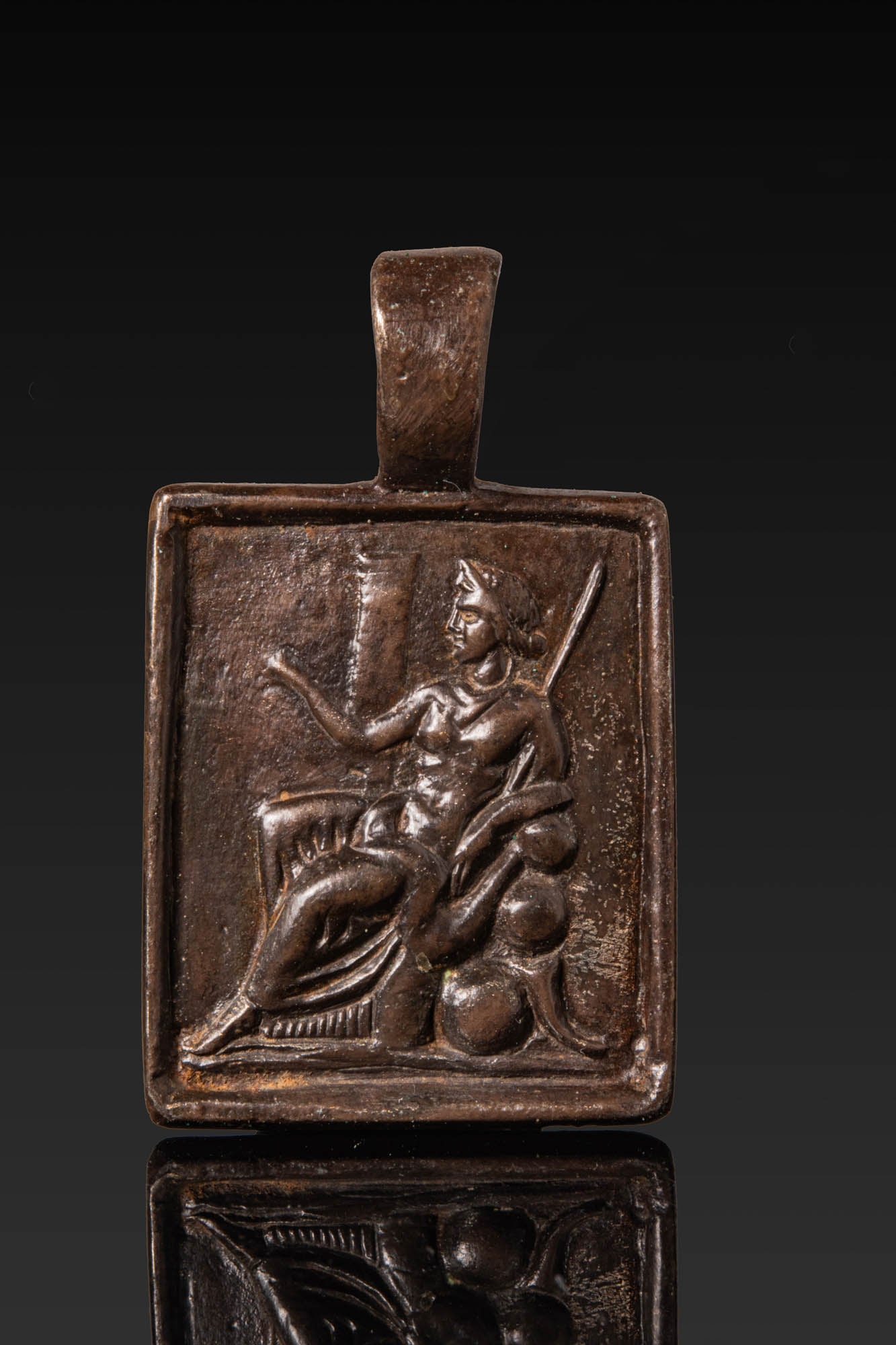 RENAISSANCE BRONZE MEDAL WITH A GODDESS ON A THRONE: Ca. AD 1450 - 1550. A bronze rectangular medal with an integral suspension loop, the obverse framed by a plain raised border. The field is modelled in relief with a seated goddess in profile, her righ