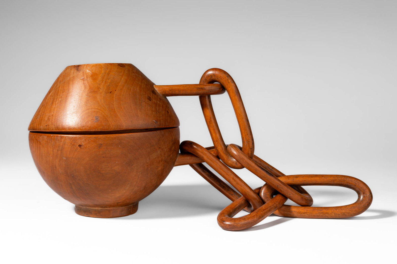 LARGE WOODEN SNUFF CONTAINER: Ca. 20th century AD. >A wooden snuff container of globular form with a fitted domed lid, the container carved from a single piece of wood and raised on a small circular foot. The vessel is attached to