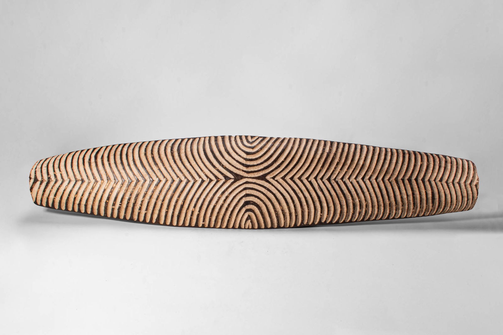 SOUTHERN CONGO LUBA SHIELD: Ca. first half of the 20th century AD. >An elongated Luba shield carved from wood, distinguished by its broad, gently tapering form. The surface is decorated with a striking pattern of alternating lig