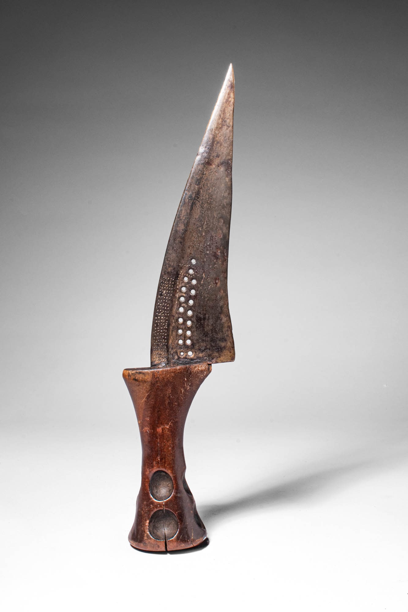 SONGYE KNIFE: Ca. 19th - 20th century AD. >A curved and perforated iron knife set in a wooden handle. This style of knife may be from the Songye people. > For similar see: University of Oslo Museum of Cultural