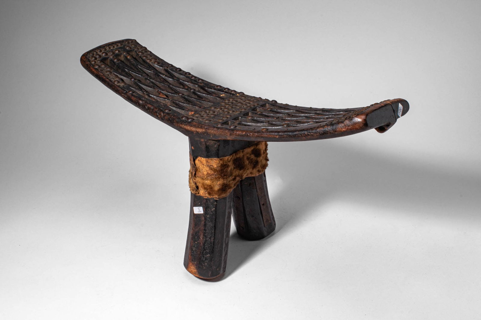 TONGAN HEAD REST: Ca. 19th century AD. >An elegantly carved Tongan headrest (kali) with a long, gently curved upper platform designed to support the nape of the neck during sleep. The surface is decorated with finely