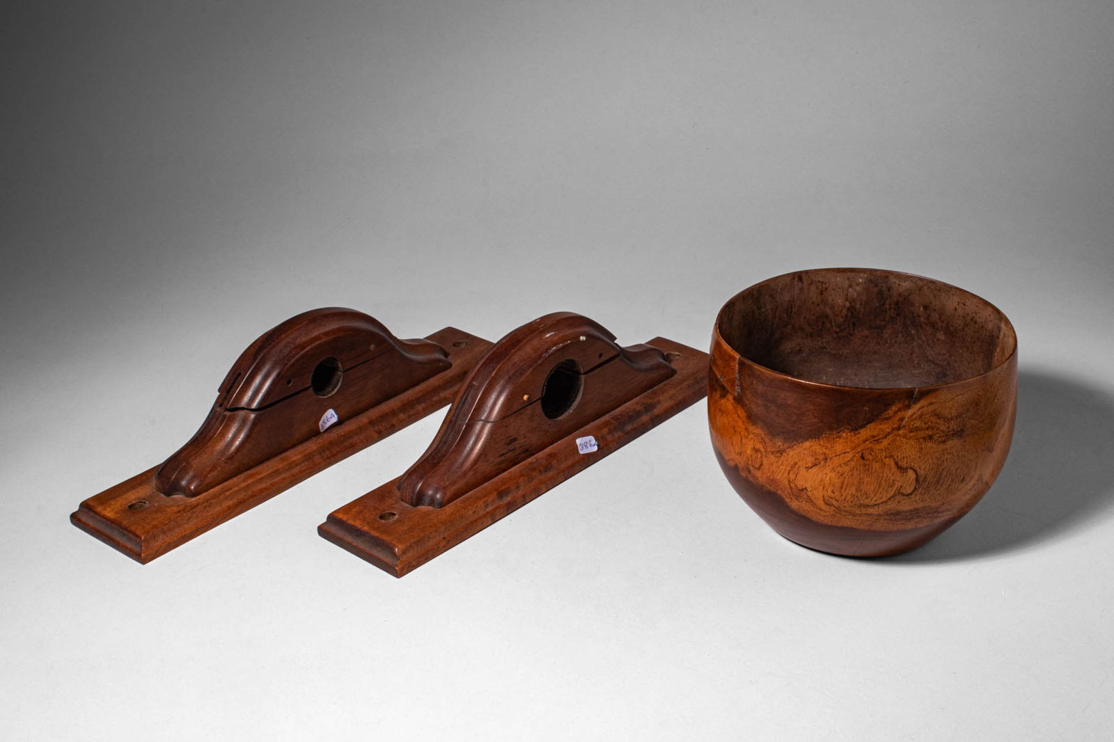 HAWAIIAN KOU WOOD PUAHALA BOWL AND PAIR OF IMPLEMENTS: Ca. 20th century AD. >A flat based carved kou wood bowl and a pair of carved wooden implements. The bowl of rounded form with a warm natural patina and prominent grain patterns characteristic of kou