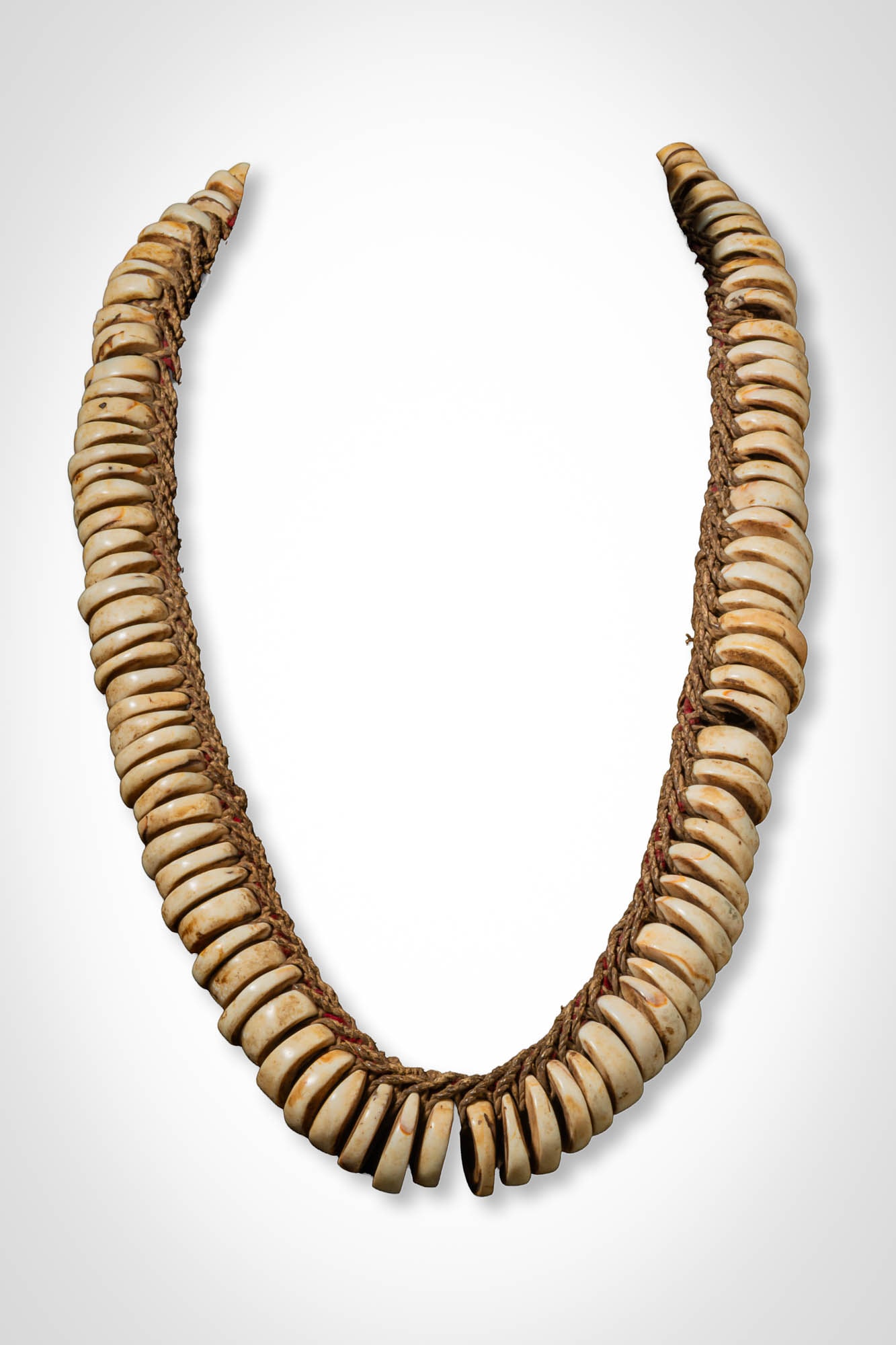 SOLOMON ISLANDS CORAL BEAD NECKLACE: Ca. 19th - 20th century AD. >A Solomon Islands necklace formed from numerous disc-shaped coral beads strung closely together on a fibre cord. Each bead is slightly irregular in thickness and surface