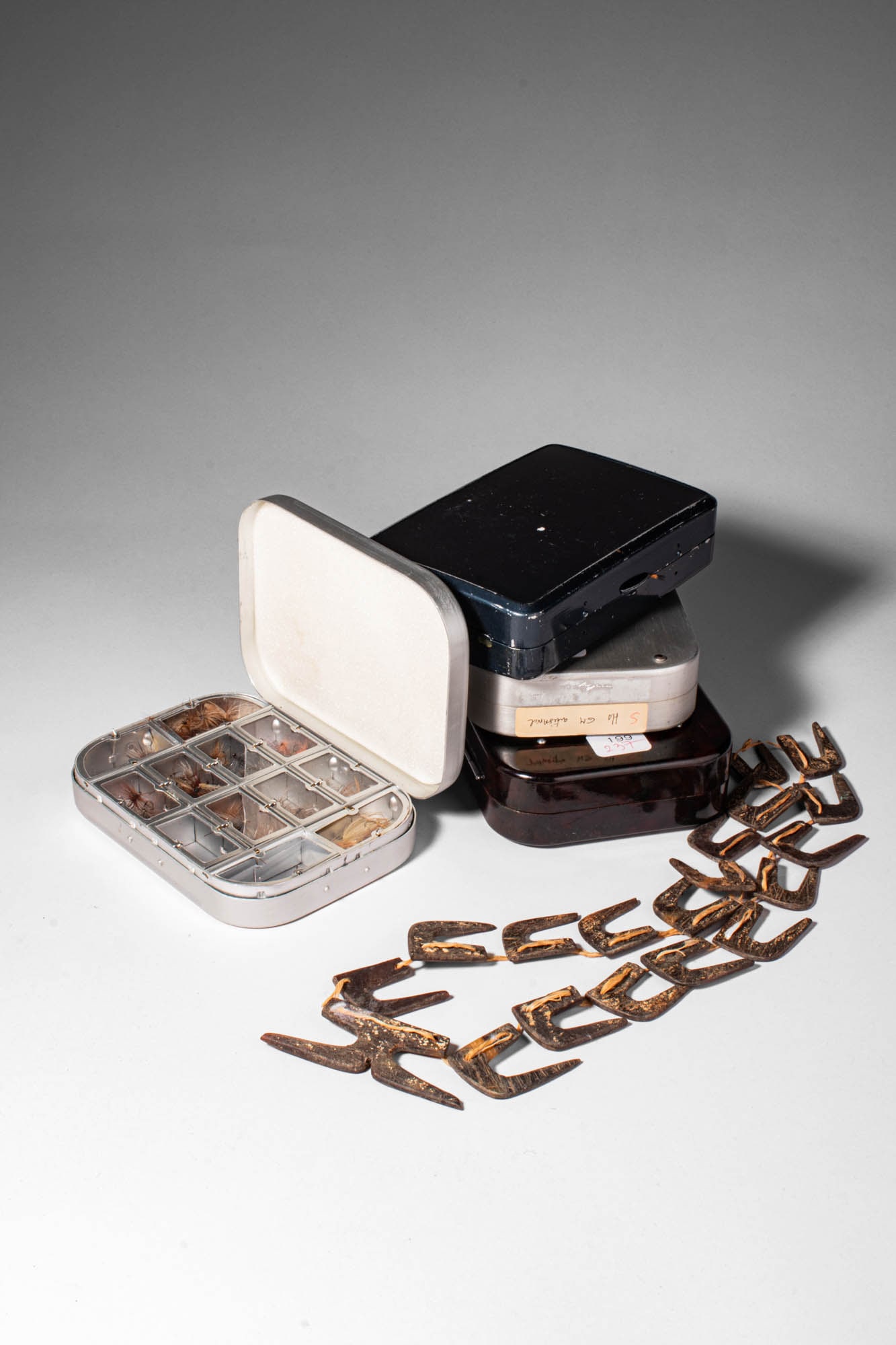 GROUP OF BAKELITE AND METAL FLY BOXES CONTAINING FISH HOOKS AND A NECKLACE OF FISH HOOKS (1 of 5)
