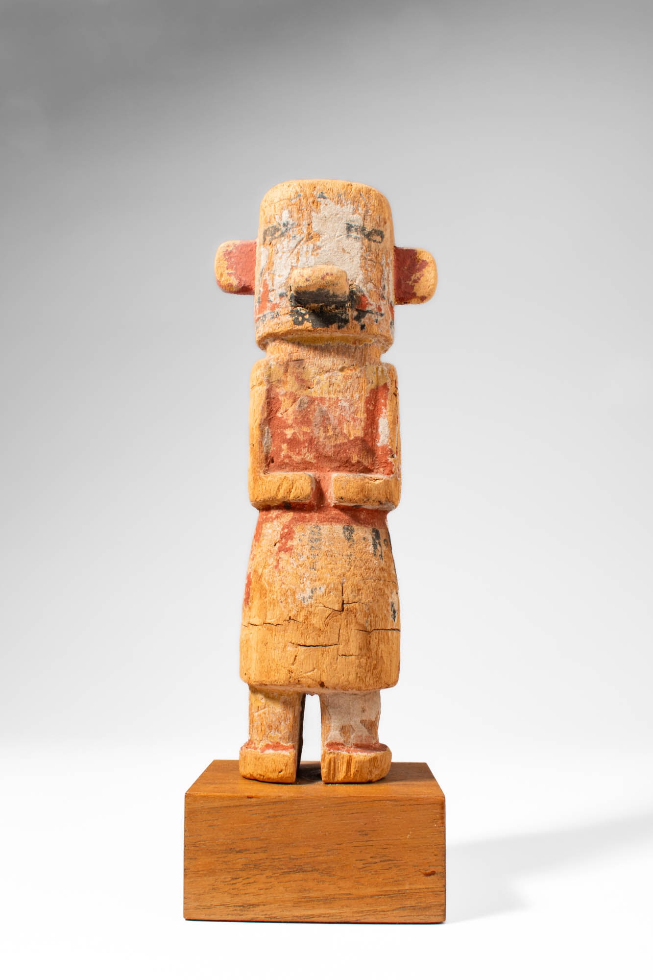 KACHINA HOPI DOLL: Ca. 20th century AD. >A Kachina Hopi doll shaped with a cylindrical head, projecting nose, and small lateral ear-like projections, the doll displays a compact, geometric form typical of Hopi represent