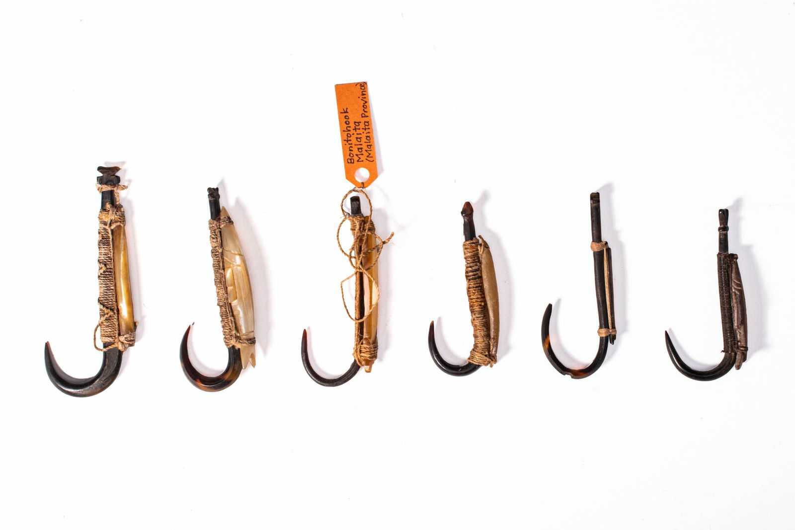 GROUP OF SOLOMON ISLANDS FISH HOOKS: Ca. 19th - 20th century AD. A group of fish hooks from the Solomon Islands. Each hook is fashioned from shell, combined with fibre bindings and cane or bone shafts. For similar see: The British Museum