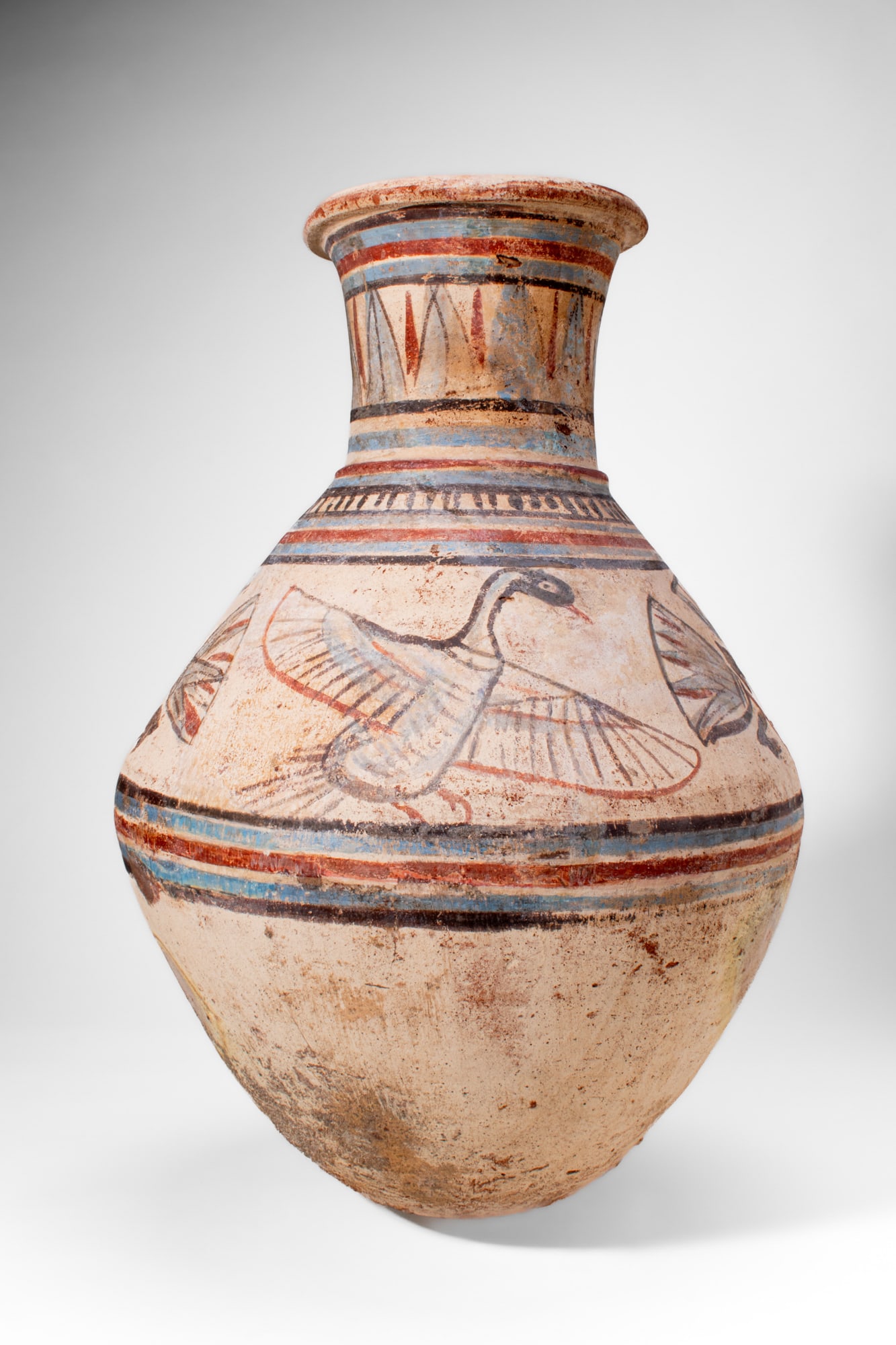 EGYPTIAN TERRACOTTA JAR WITH BIRDS: Amarna Period, Ca. 1353 - 1336 BC. A pottery jar with a globular body narrowing to a tall cylindrical neck with a thickened everted rim. The neck is encircled by horizontal bands in red, blue, and bla