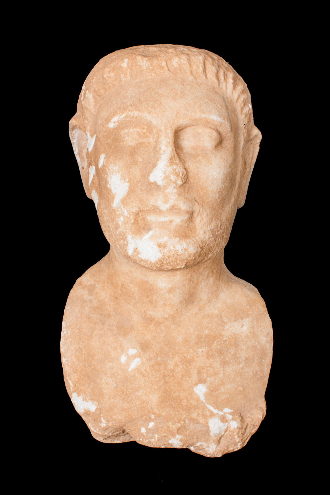CYPRIOT LIMESTONE BUST OF NOBLEMAN: Ca. 500 - 300 BC. A limestone bust of a nobleman with close-cropped hair and short incised locks across the fringe. The oval face shows a broad brow, shallowly modelled eyelids, a straight nose, small