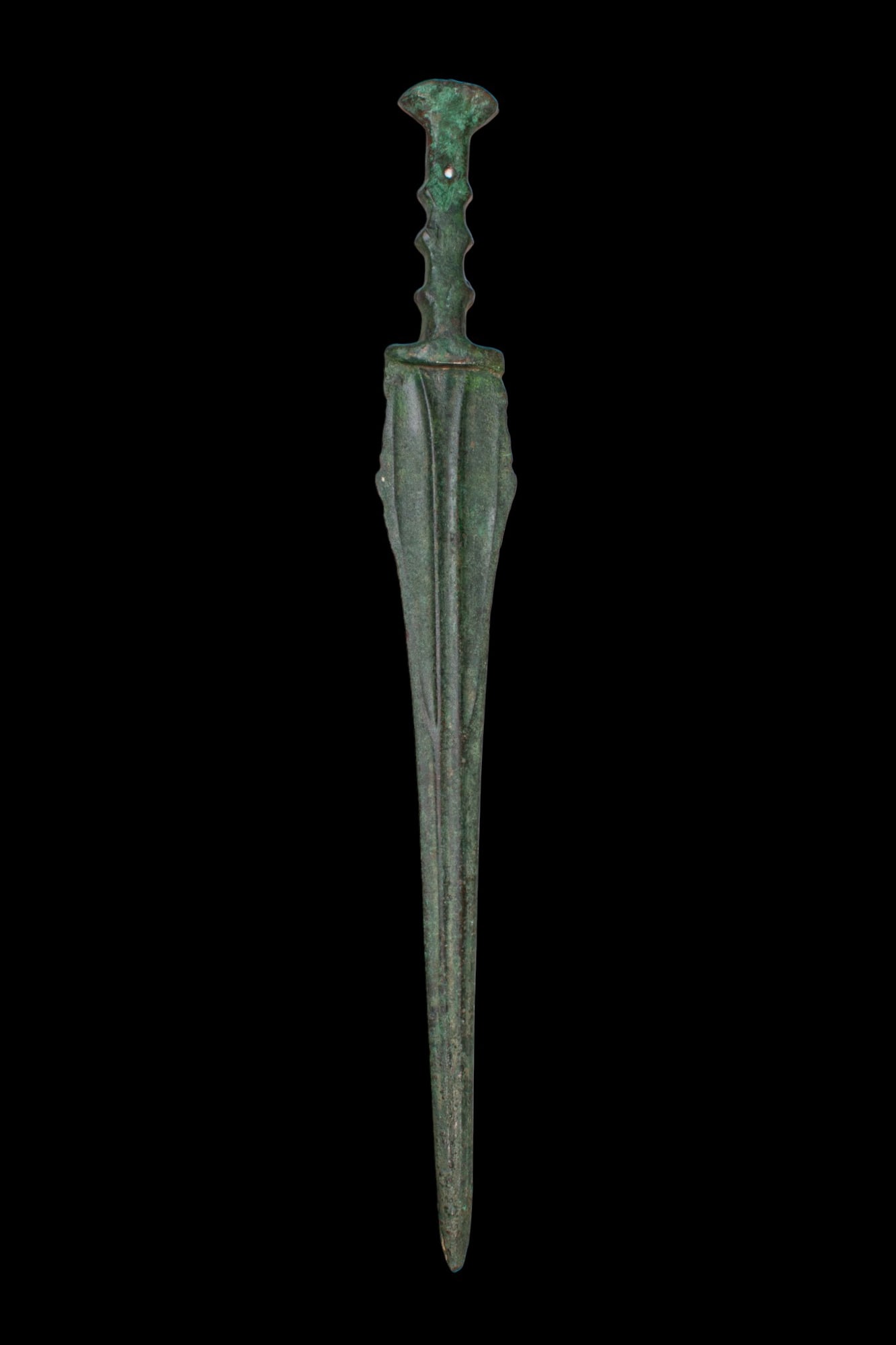 BRONZE AGE / EARLY GREEK PERIOD BRONZE SWORD: Ca. 1200 - 800 BC. A bronze sword with an integral hilt, the pommel flaring above a straight grip with scalloped finger notches along each side. The blade tapers to a point, with a central, narrow gro