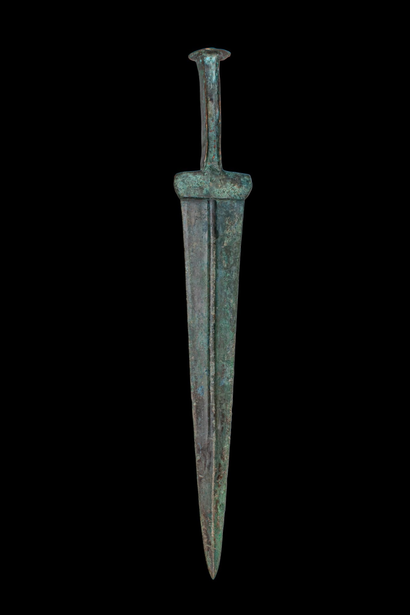 BRONZE AGE / EARLY GREEK PERIOD BRONZE SWORD: Ca. 1200 - 800 BC. A bronze sword with an integral hilt and a disc-shaped pommel above a narrow grip. The blade is broad at the base and tapers to the point, with a longitudinal central channel on eac