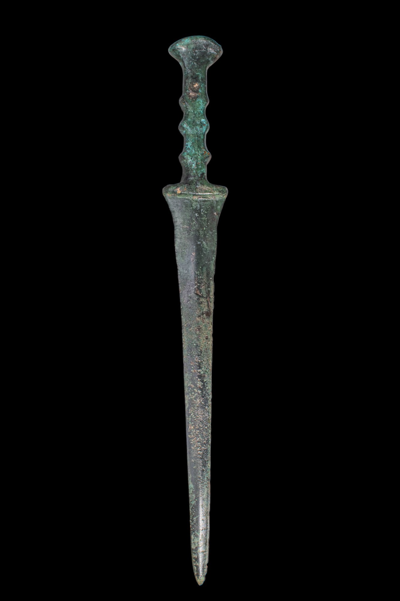 BRONZE AGE / EARLY GREEK PERIOD BRONZE DAGGER: Ca. 1200 - 800 BC. A bronze dagger with a long, narrow blade tapering to a sharp point. A pronounced medial ridge runs to the point, the blade broadening slightly at the shoulders into a short guard.