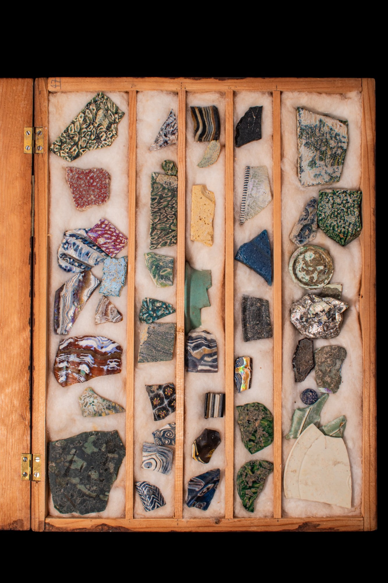 COLLECTION OF ROMAN POLYCHROME GLASS SECTILIA: Ca. 100 BC - AD 100. A collection of polychrome glass pieces, including assorted inlay fragments; mosaic, marbled and banded glass in varied colours. Accompanied by a compartmented wooden box. For sim