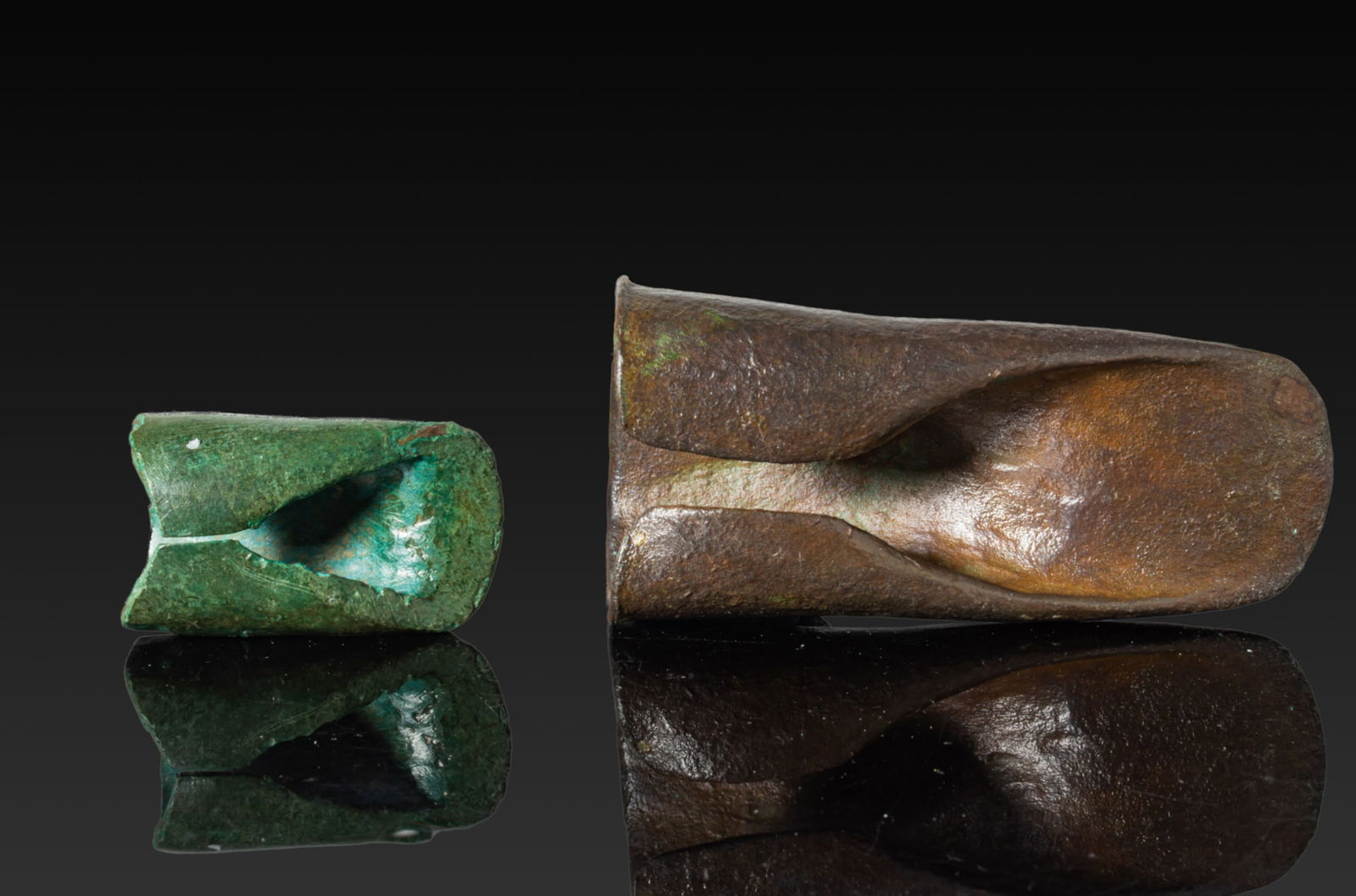 PAIR OF CELTIC BRONZE AXE HEADS: Ca. 1200 - 800 BC. A pair of bronze axe heads, each formed from a single sheet rolled inwards, with the opposing flanges turned in to form a socket. For similar see: The British Museum, Museum