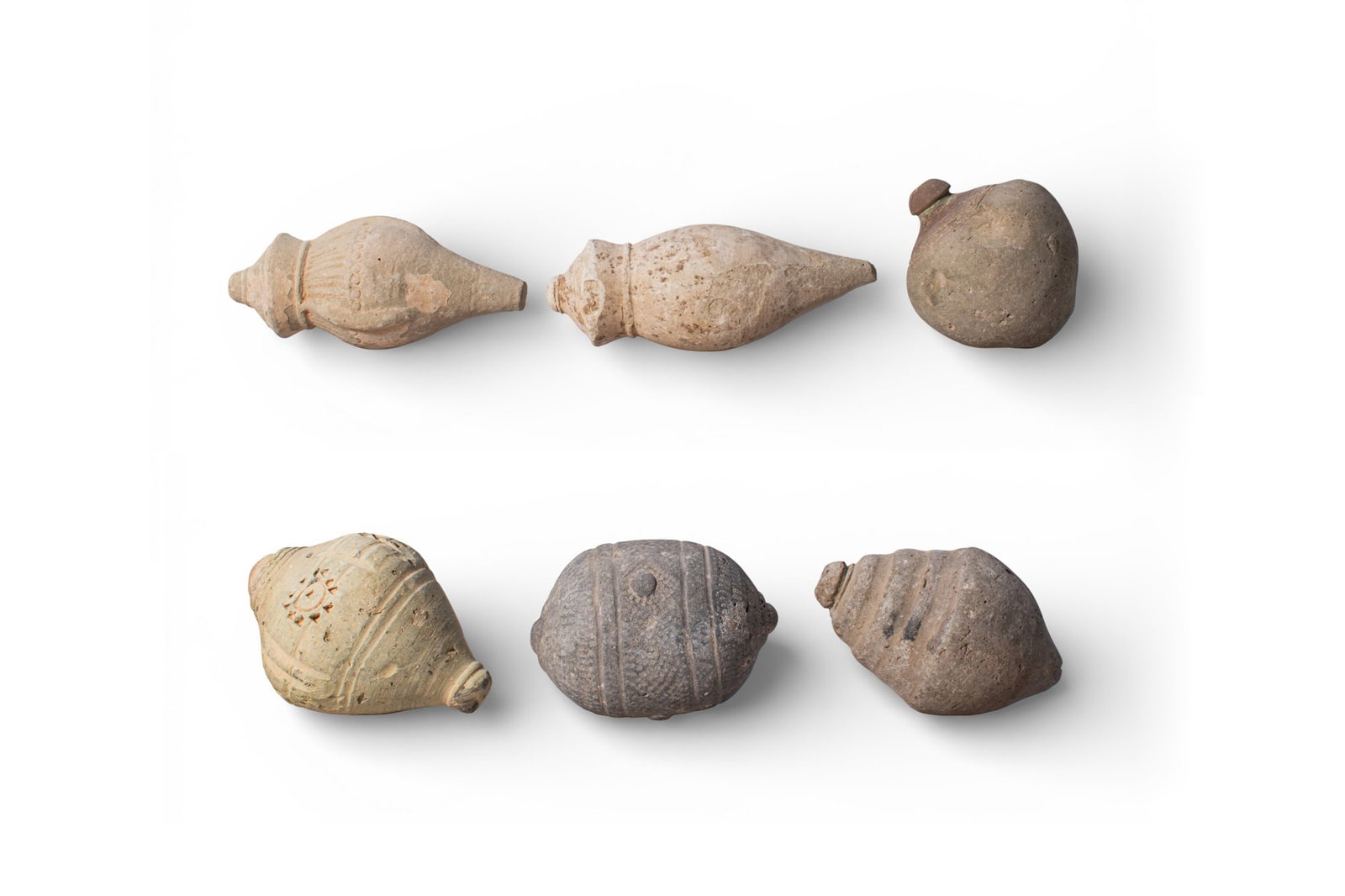 COLLECTION OF BYZANTINE TERRACOTTA GRENADES: Ca. AD 1000 - 1200. A collection of six terracotta grenades, including, from left to right: an elongated example with a pointed base, a rounded ribbed shoulder with vertical ridges, and a stepped coll