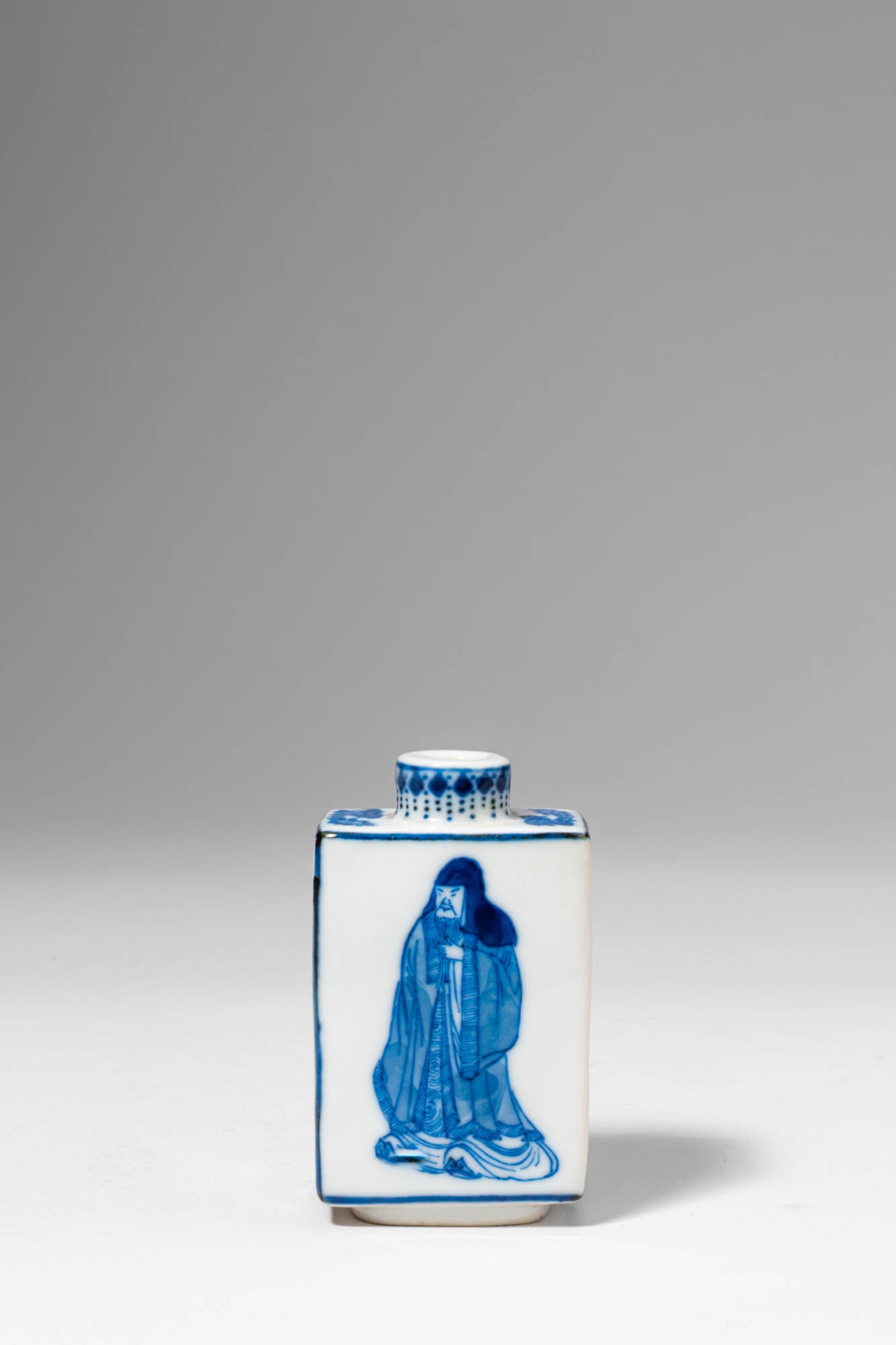 CHINESE BLUE AND WHITE FIGURAL SNUFF BOTTLE, DEPICTING XIE AN: Qing Dynasty, Ca. AD 1644 - 1912. >A porcelain snuff bottle of rectangular form with gently rounded shoulders, rising to a short cylindrical neck. The body is delicately painted in underglaze cobalt b