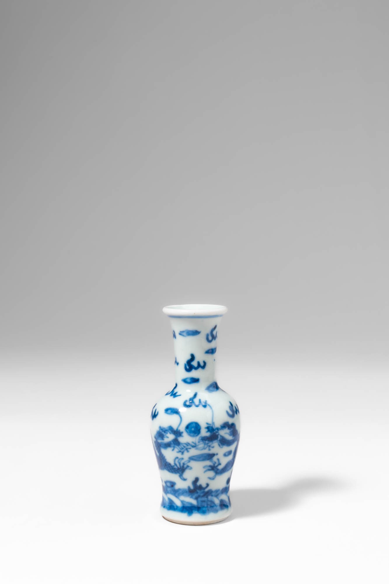 CHINESE BLUE AND WHITE SNUFF BOTTLE WITH ?DOUBLE DRAGONS PLAYING WITH A PEARL: Qing Dynasty, Ca. AD 1644 - 1912. >A porcelain snuff bottle of baluster form, rising from a neatly finished foot to a tall, slender neck with a slightly flared rim. The body is decorated in underglaze
