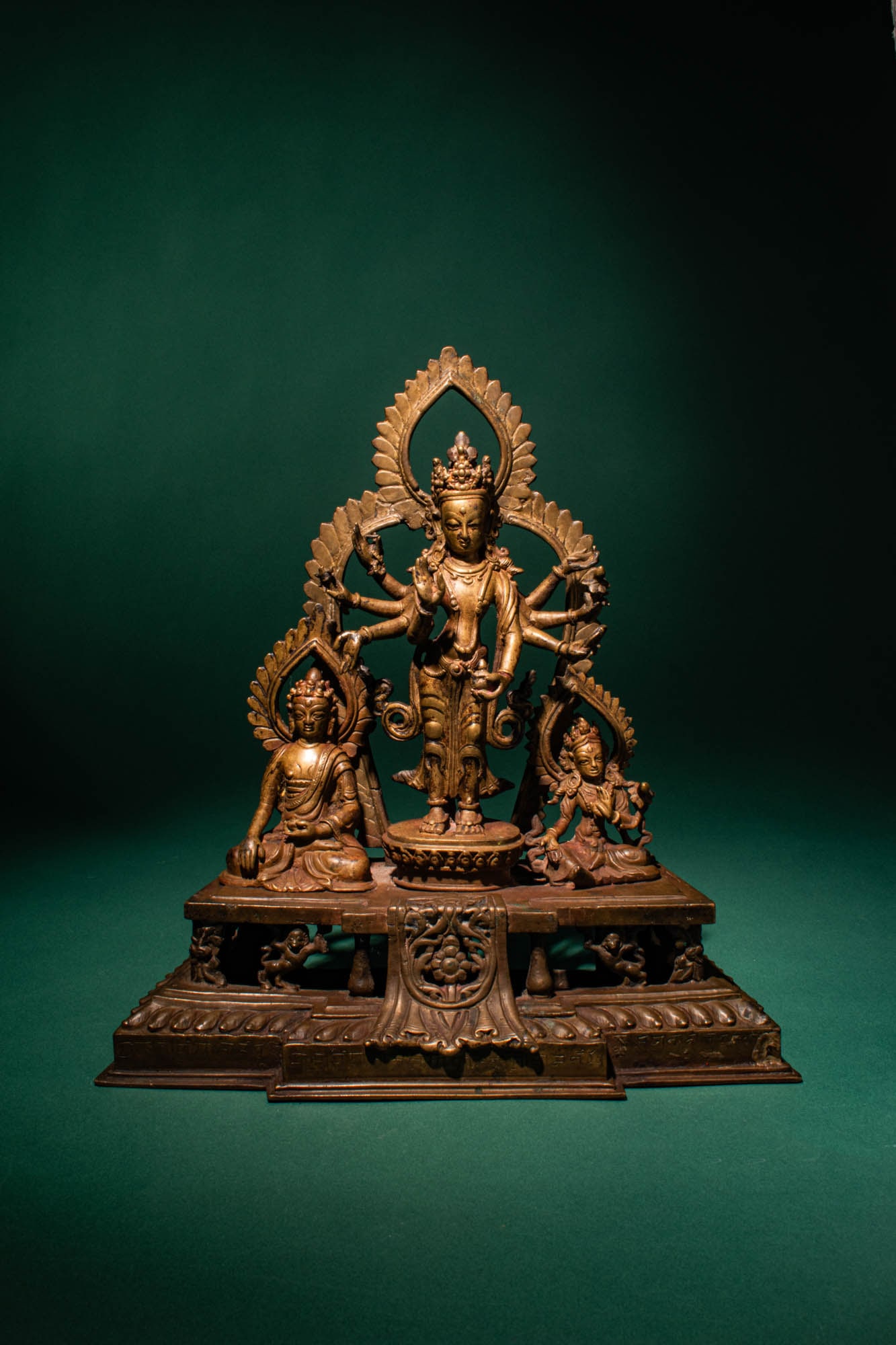 NEPALESE BRONZE AMOGHAPASHA WITH BUDDHA SHAKYAMUNI AND TARA: Ca. 18th - 19th century AD. >A finely cast bronze triadic group centred on Amoghapasha Lokeshvara, standing in elegant frontal pose upon a lotus pedestal and backed by an elaborate flaming aureole. Th