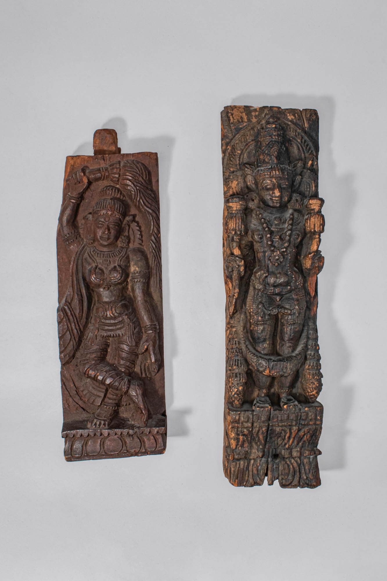 PAIR OF WOOD CARVINGS DEPICTING HINDU GODS: Ca. 18th-19th century AD. A carved pair of wooden architectural panels, each depicting a Hindu deity in high relief. These panels were likely once part of a temple or shrine structure, serving as deco