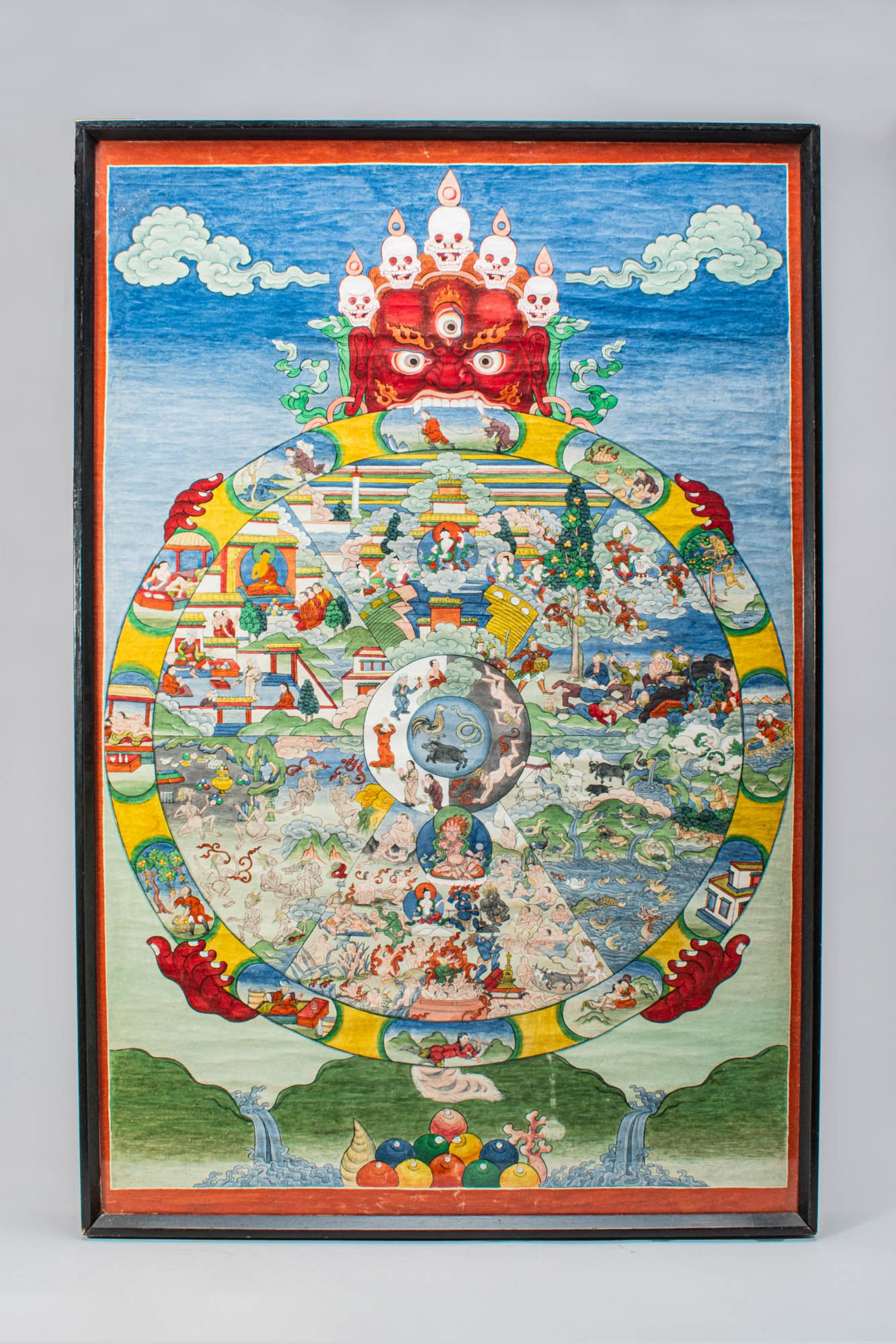 TIBETAN THANGKA OF THE WHEEL OF LIFE: Ca. 19th-20th century AD. A finely painted thangka depicting the Bhavachakra, or Wheel of Life, vividly illustrating the Buddhist concept of samsara - the cycle of existence. At the centre are the Thr
