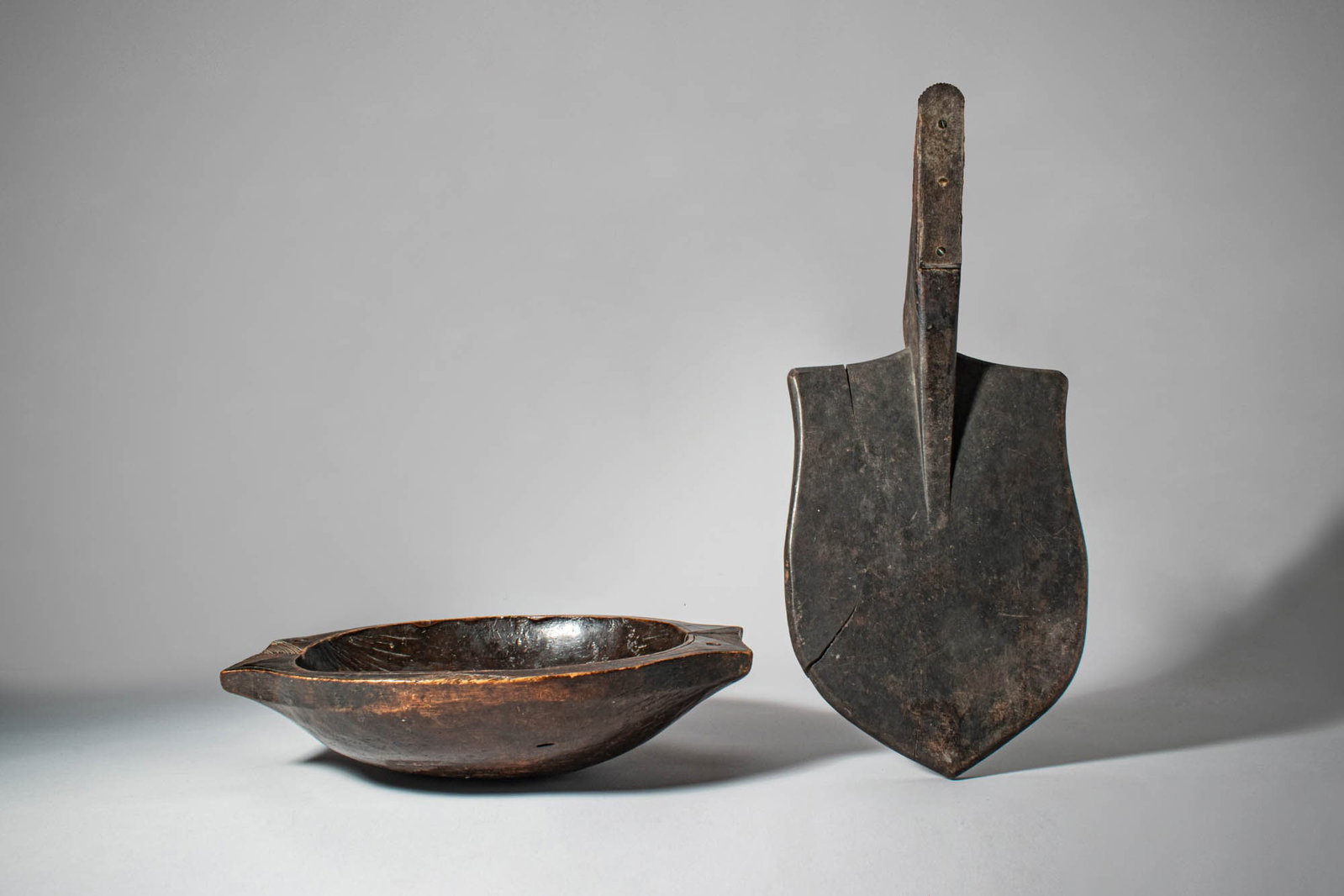 AFRICAN WOODEN DISH AND OCEANIC COCONUT RASP: Ca. late 19th - early 20th century AD. >A group comprising a carved wooden dish of shallow, rounded form with slightly everted rim, together with an Oceanic coconut rasp consisting of a carved wooden 