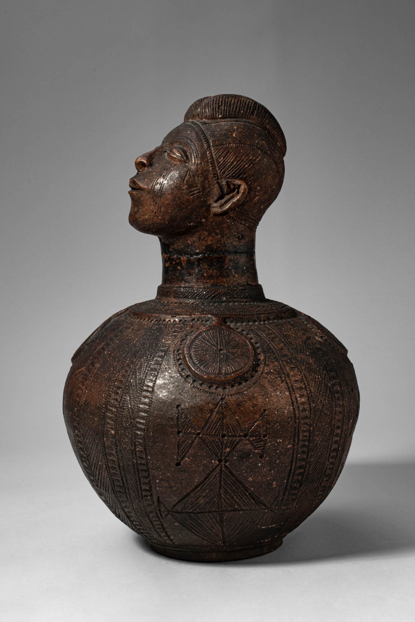 ZANDE ANTHROPOMORPHIC CLAY VESSEL BY MBITIM: Democratic Republic of the Congo, Ca. early 20th century AD. >A finely worked anthropomorphic clay vessel attributed to the artist Mbitim, combining sculptural representation with functional form. The