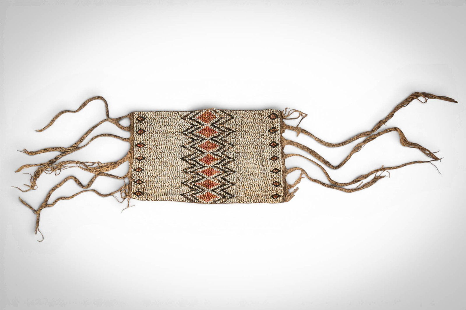SOLOMON ISLANDS ARM BAND: Ca. late 19th - early 20th century AD. >An arm band of rectangular woven form, worked in natural fibre with a central band of geometric ornament in black and reddish-brown, flanked by smaller repeatin