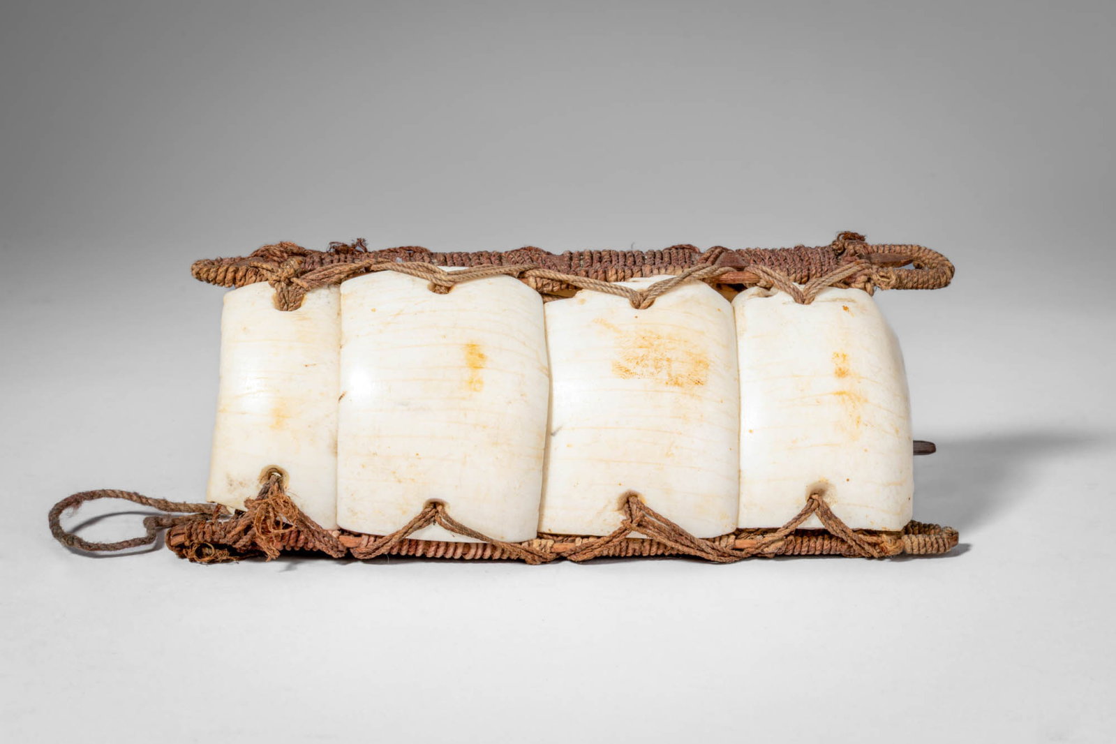 PAPUAN ELEMA ARCHER'S ARMBAND: Ca. early 20th century AD. >An armband composed of a Conus shell, of the type traditionally worn by men as a status symbol. The shell material was used as currency in the region, associating the ornam