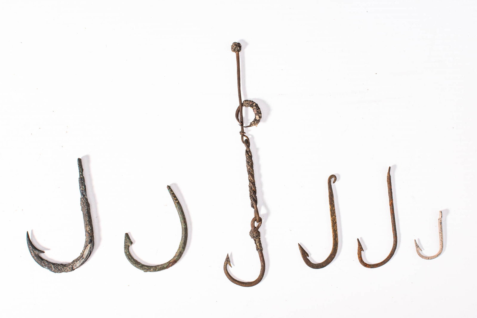 GROUP OF METAL FISH HOOKS: Ca. 19th century AD. A collection of six forged metal fish hooks of varying sizes and forms, with simple barbed points.Size: 55-140mm x 25-40mm; Weight: 40gProvenance: Prince collection, 1990s-2014; E