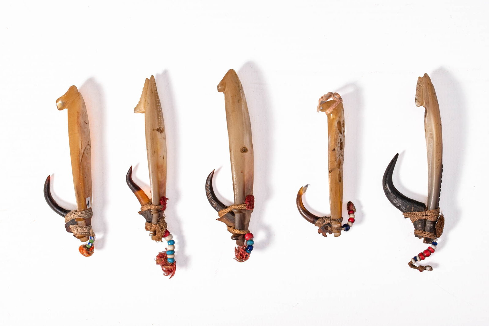 GROUP OF SOLOMON ISLANDS FISH HOOKS: Ca. 19th century AD. A beautiful group of five Solomon Islands fishing hooks, each finely constructed from pearl shell and turtle shell with fibre lashings, natural cordage, and decorative beads in re