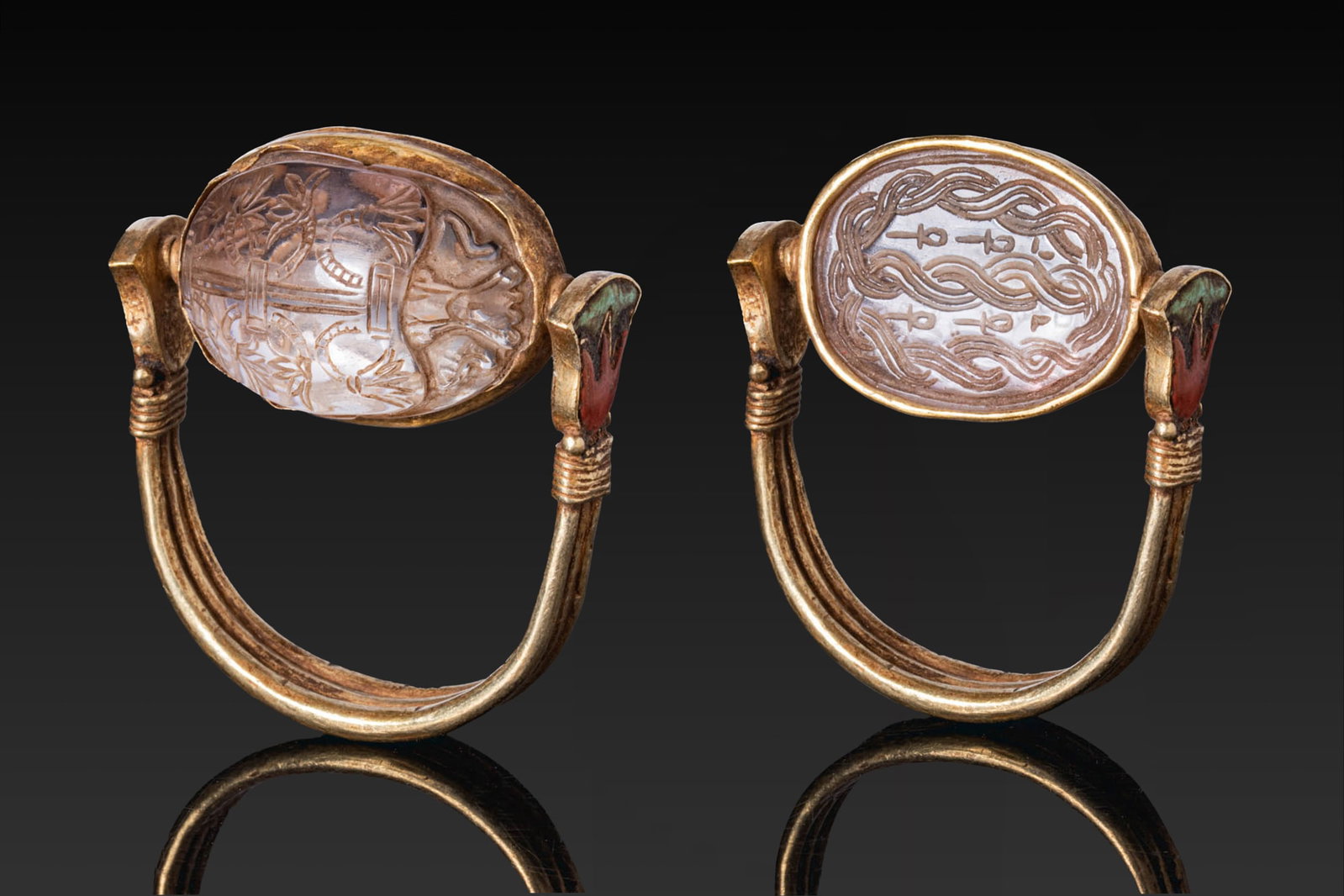 EGYPTIAN ROCK CRYSTAL SCARAB WITH SEMA-TAWY AND ANKH MOTIFS IN GOLD SWIVEL RING: Middle Kingdom. Ca. 2055 - 1790 BC. A rock crystal scarab with a domed back carved with an elaborated sema-tawy motif (the symbol of the unification of Egypt), and a flat underside engraved with plait