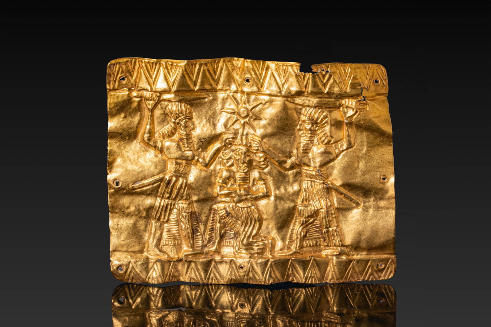 RARE NEO-ASSYRIAN GOLD LEAF WITH RITUAL FIGHTING SCENE: Ca. 800 - 600 BC. A rectangular sheet of gold leaf with a repousse figural panel framed above and below by bands of repeated triangles. The central scene shows a kneeling figure flanked by two stridin
