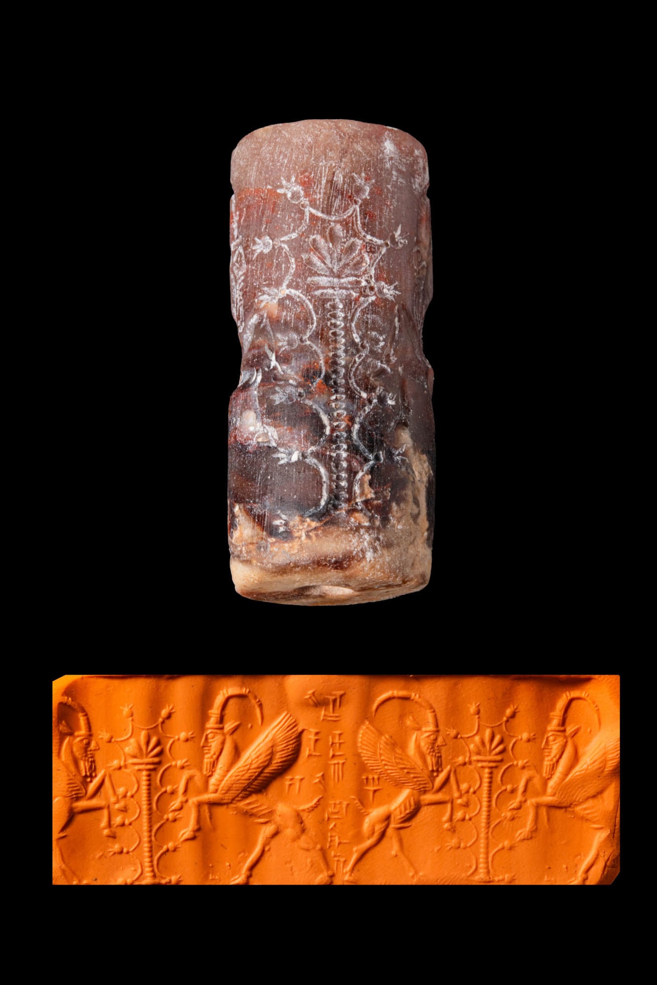 NEO-ASSYRIAN DARK REDDISH STONE CYLINDER SEAL WITH MYTHICAL CREATURES, A TREE OF LIFE, AND CUNEIFORM: Ca. 800 - 650 BC. A dark reddish stone cylinder seal, drilled longitudinally and engraved with a schematic tree of life flanked by two mythical creatures, with a cuneiform inscription. Size: 38mm x 17