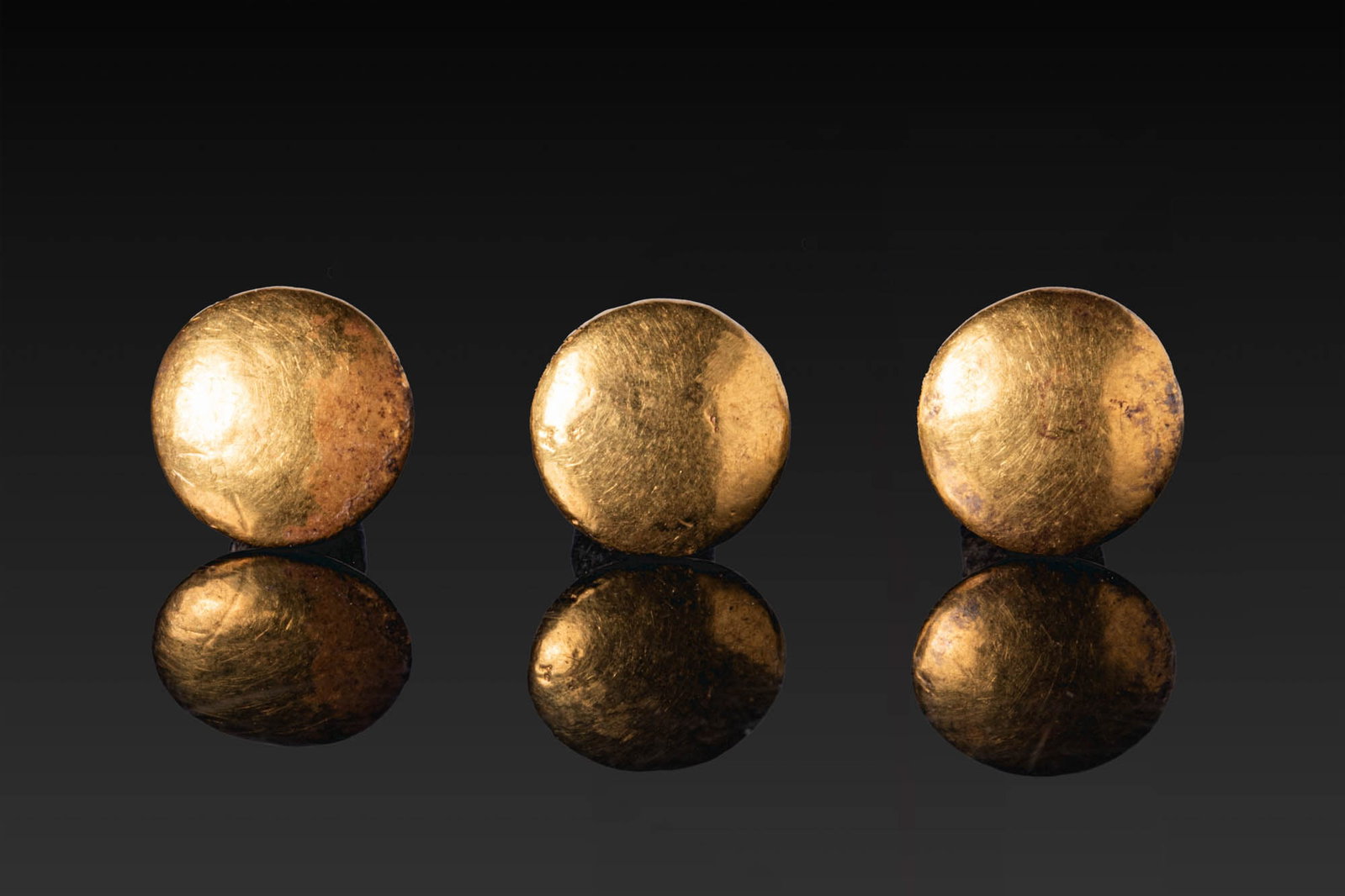 RARE COLLECTION OF EGYPTIAN GOLD AND BRONZE MUMMY EAR PLUGS: Late Period, Ca. 664 - 332 BC. A collection of three mummy ear plugs, each with a convex circular gold cap above a tapering bronze shank with a rounded and pierced terminal. Size: 11-11mm x 8-8mm; Wei