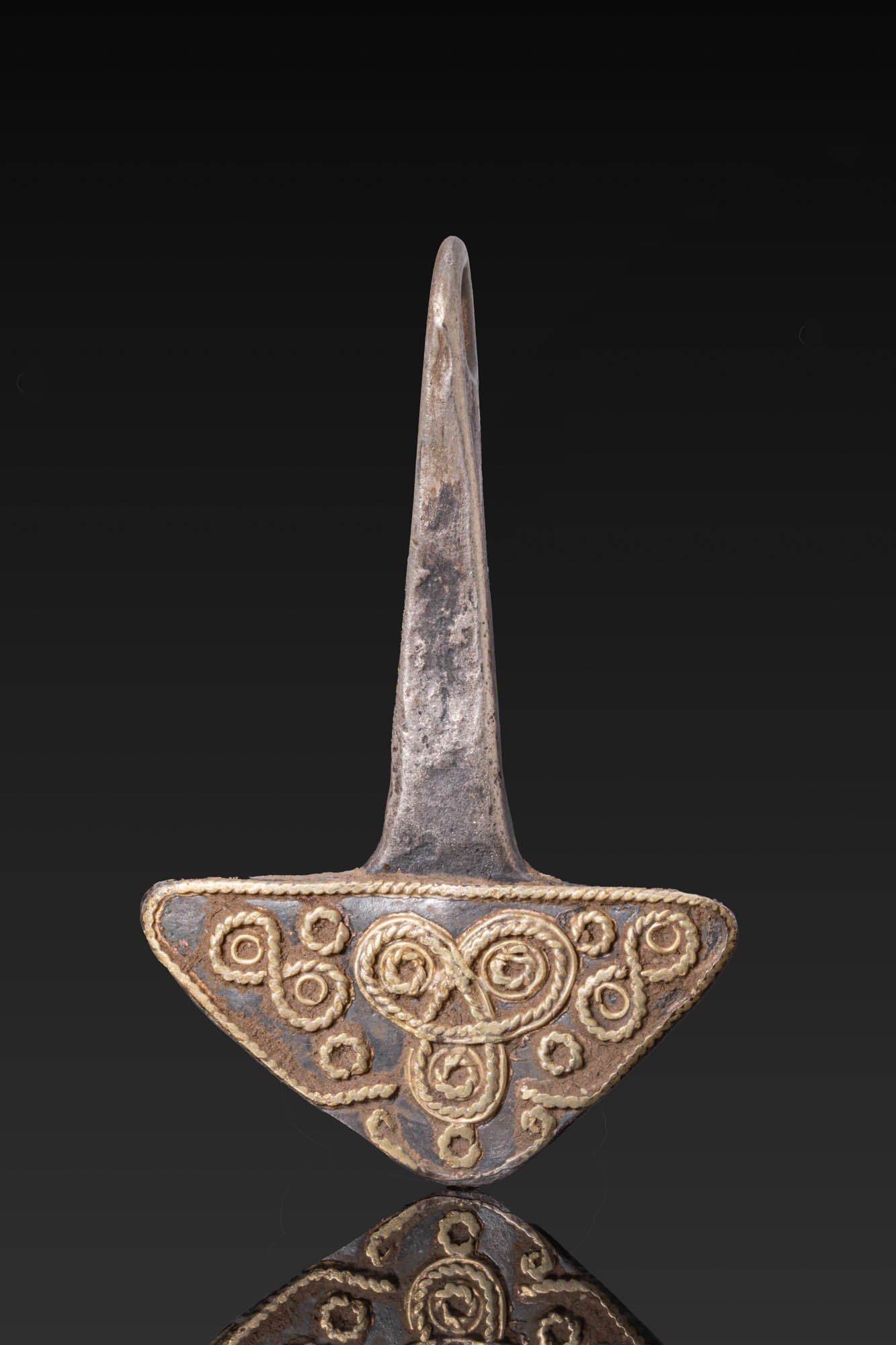 VIKING SILVER-GILT MJOLNIR AMULET: Ca. AD 700 - 1000. A silver-gilt Mjolnir amulet with a tall tapering shaft ending in a loop above a broad flaring head decorated with applied twisted wire arranged in spirals, roundels, and a central 