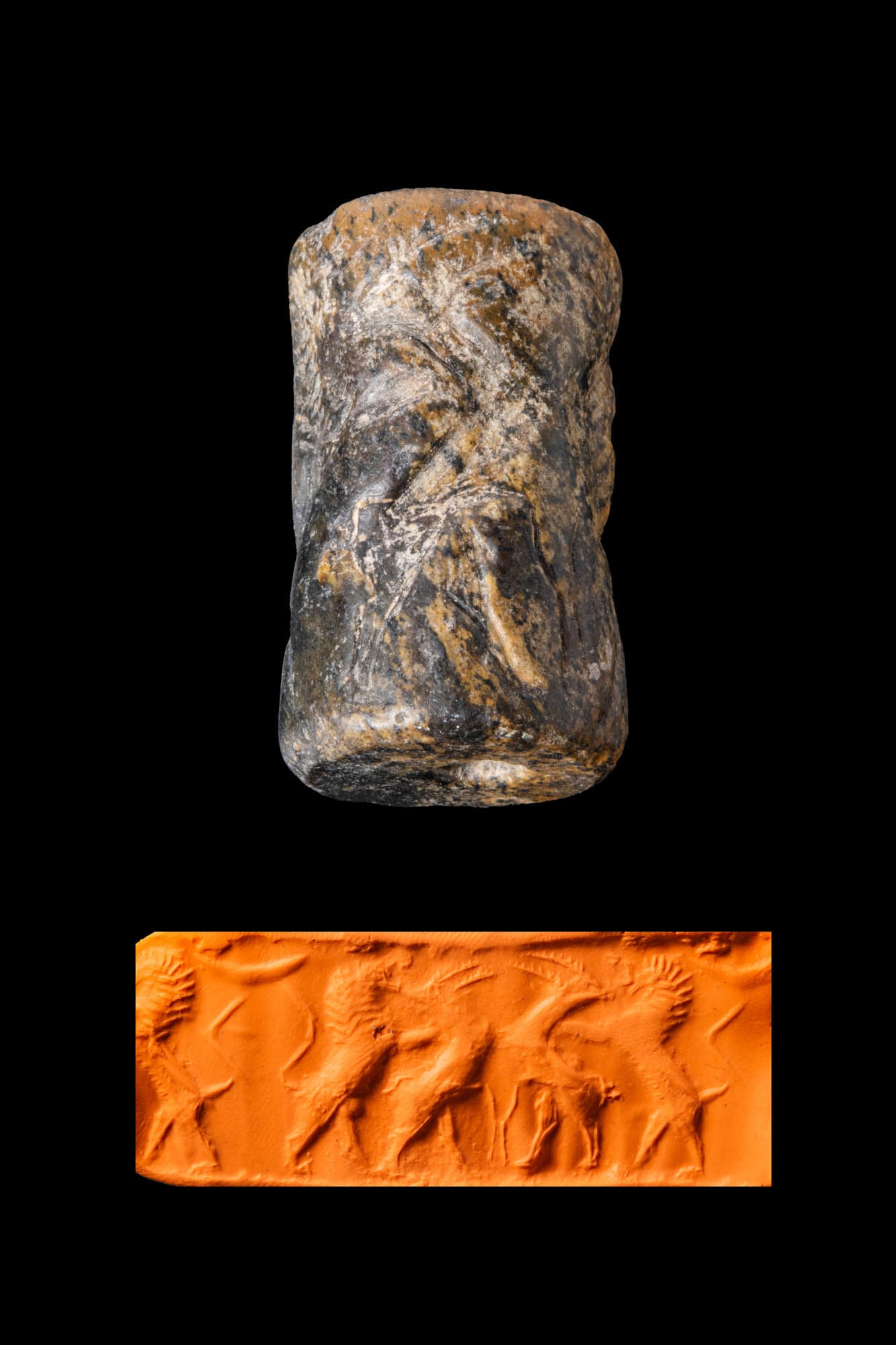 EARLY DYNASTIC TO EARLY AKKADIAN BLACK STONE CYLINDER SEAL WITH LIONS AND GAZELLES: Ca. 2600 - 2300 BC. A black stone cylinder seal, drilled longitudinally and engraved with lions attacking gazelles. Size: 35mm x 20mm; Weight: 26g Provenance: Private London collection of an Ancient A