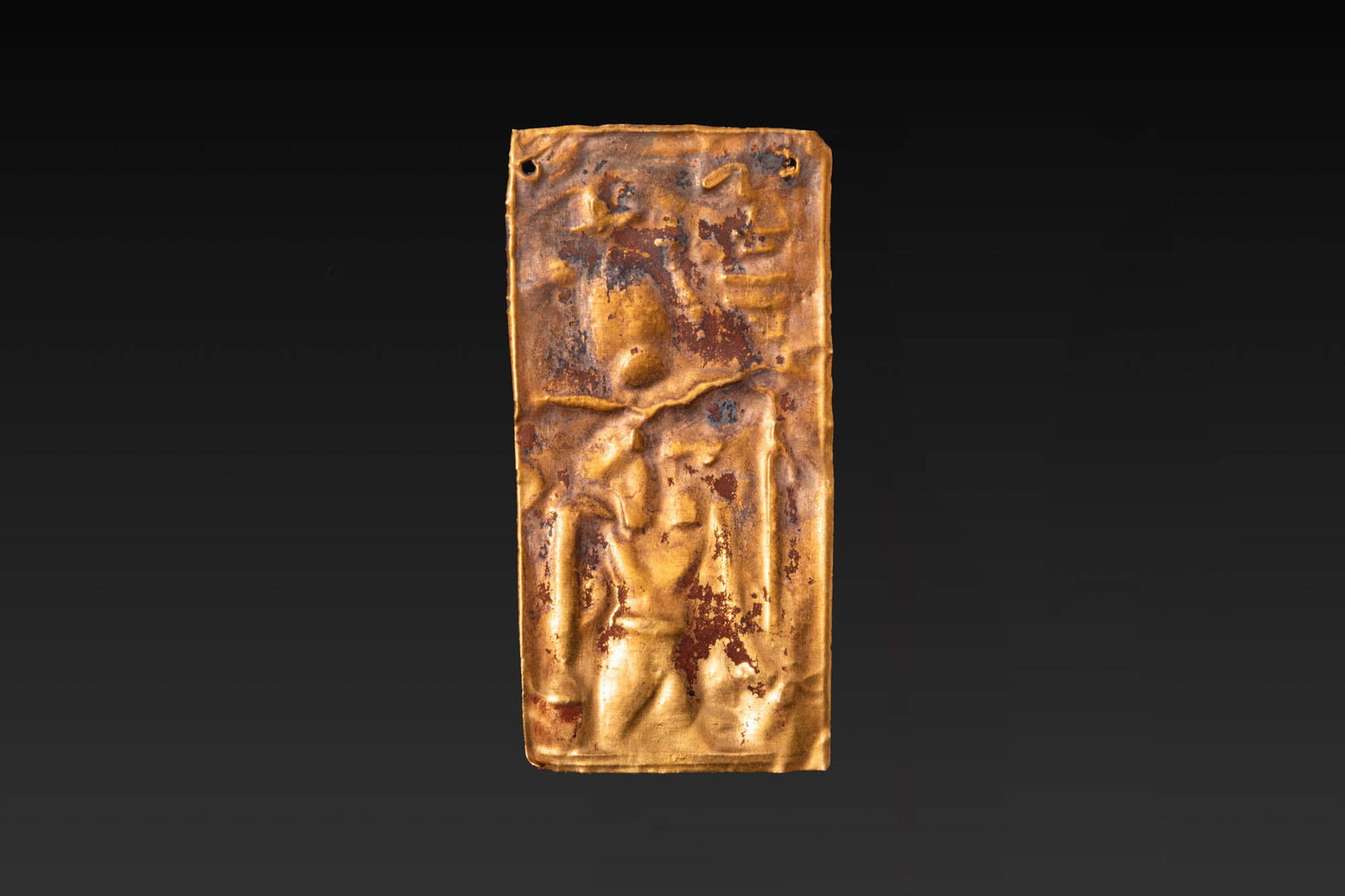 EGYPTIAN GOLD PLAQUE WITH KHNUM WEARING THE ATEF CROWN: Late Period–Ptolemaic Period. Ca. 664–30 B.C. A rectangular gold plaque decorated in repousse with the god Khnum in standing position, wearing the atef crown and holding a long staff in his right 