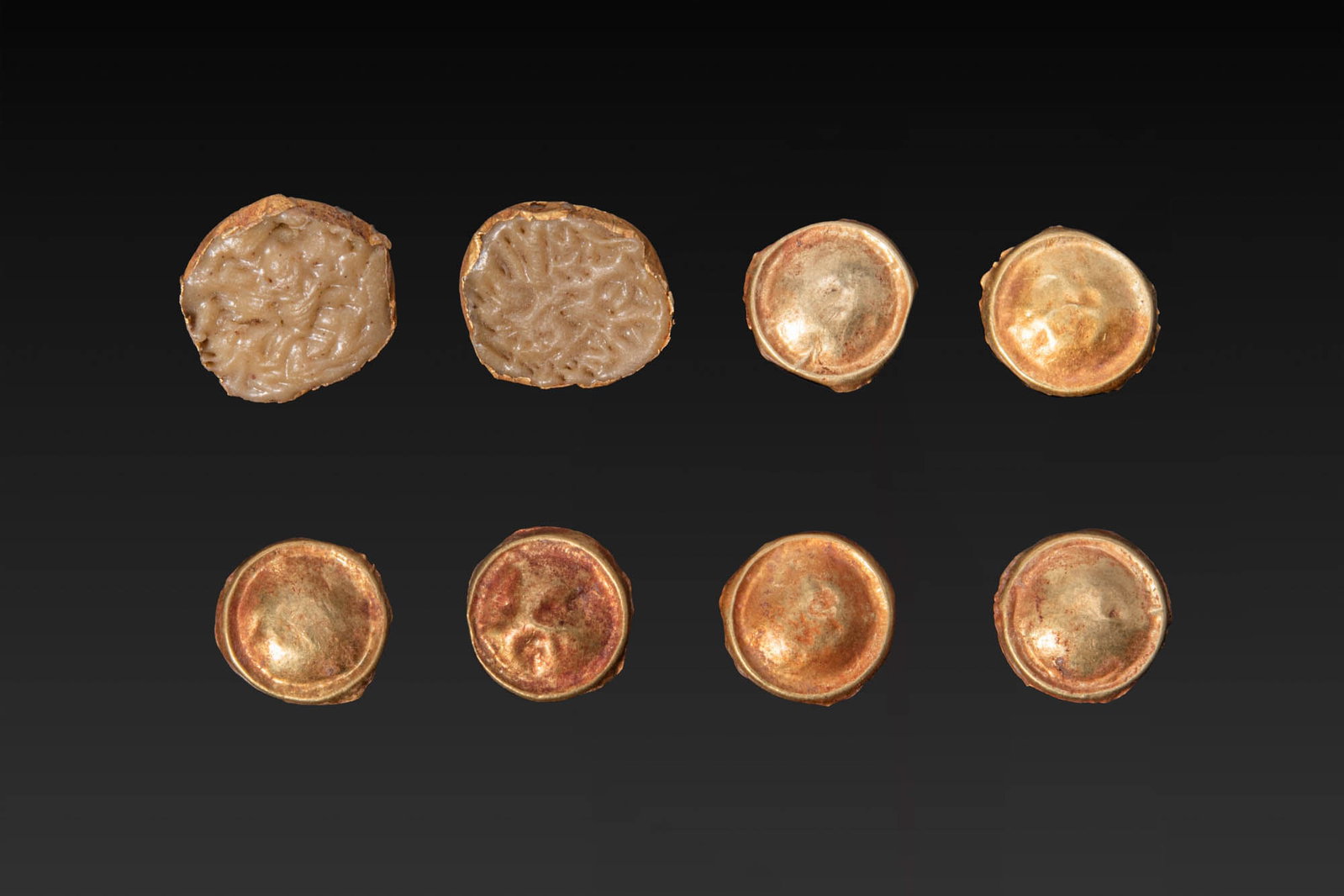 COLLECTION OF GREEK HIGH KARAT GOLD APPLIQUES: Ca. 800 - 600 BC. A collection of eight gold appliques, each formed as a domed disc of thin sheet with a raised rim and a soldered attachment loop on the reverse. Size: 10-12mm x 10-12mm; Weight: 3g P
