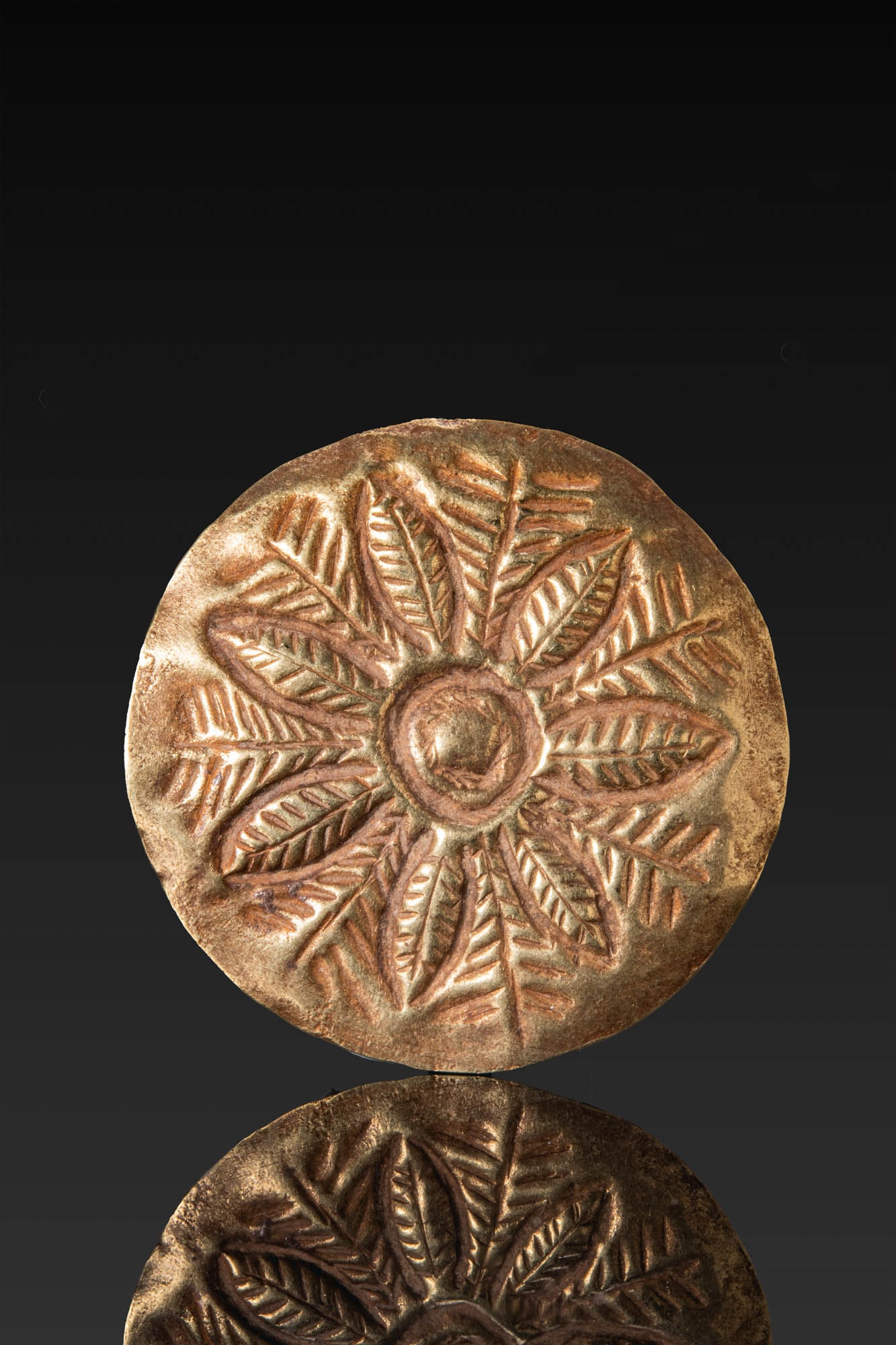 GREEK GOLD ROSETTE APPLIQUE: Ca. 600 - 400 BC. A gold applique of circular, slightly domed form with a rosette composed of a central boss encircled by seven pointed petals and radiating leaves. For similar see: W. Seipel, Efes Ar