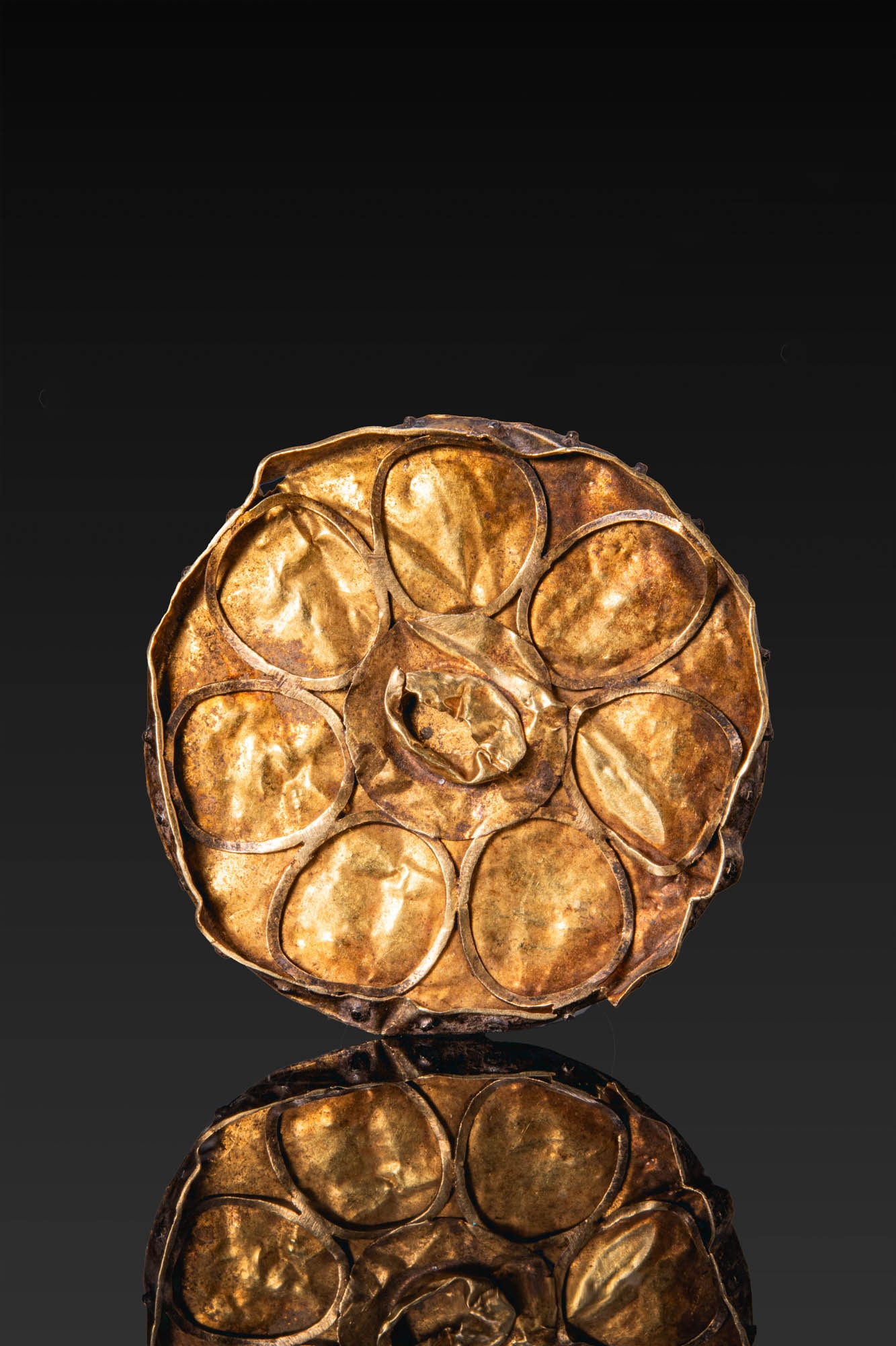 GREEK GOLD ROSETTE APPLIQUE: Ca. 600 - 400 BC. A gold applique of circular form with a rosette composed of a central cell encircled by seven oval petals. For similar see: E. M. De Juliis, Gli Ori di Taranto in Eta Ellenistica, ca